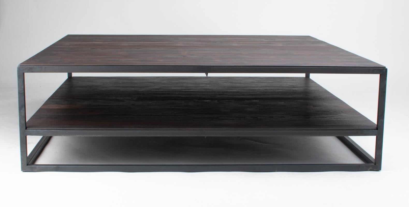 EN STOCK Y LISTO PARA ENVIAR
Elegante fusión de fuerza industrial y calidez orgánica, esta mesa de centro belga hecha a mano presenta un tablero de suelo de teca teñida de color carbón meticulosamente incrustado en una sólida estructura de acero