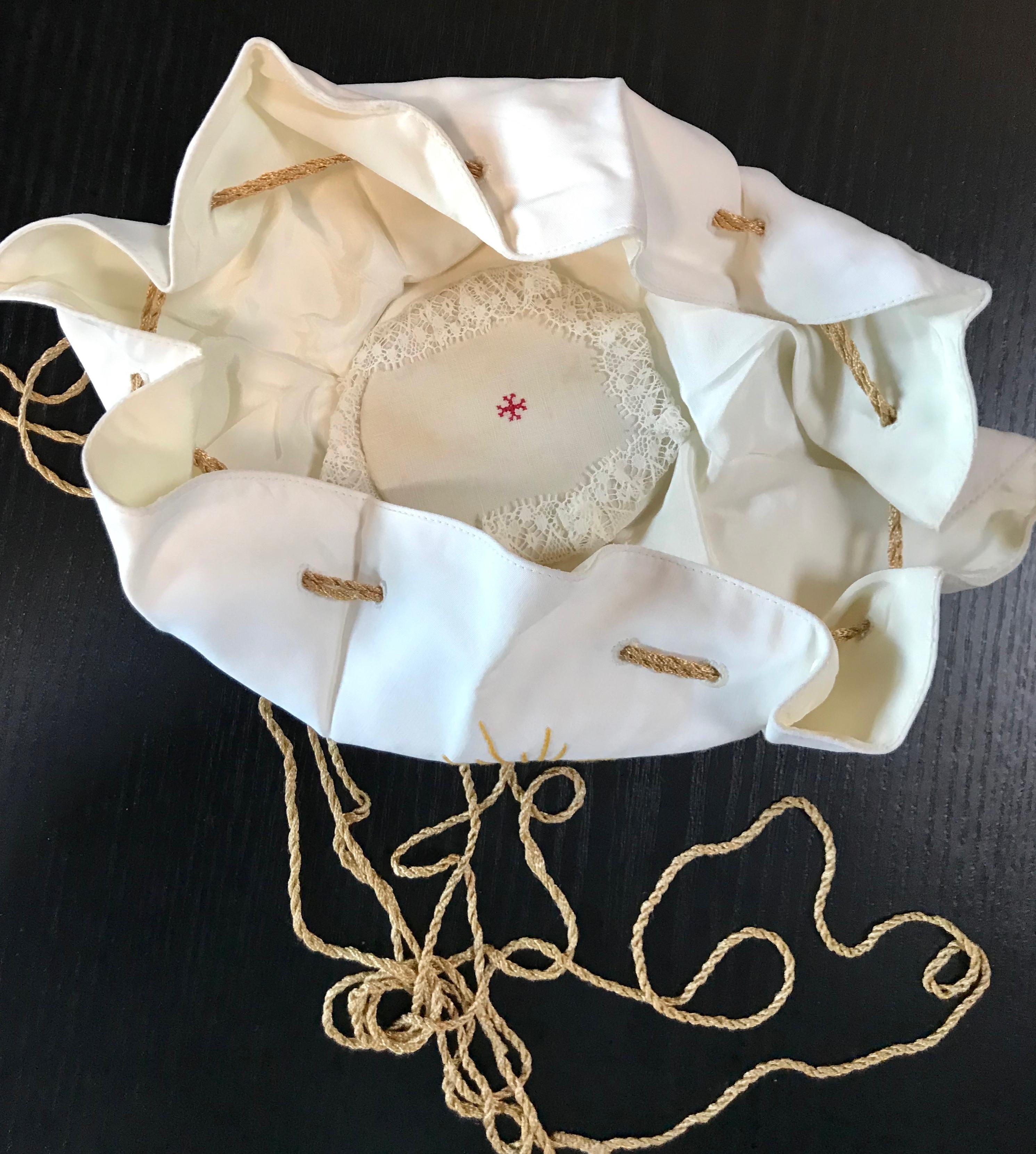 This hand embroidered linen bag was used to carry the communion Host wafers to the older or sick that could not come to the Church to receive communion. The Host was wrapped in a corporal in this small burse linen bag which was suspended round the