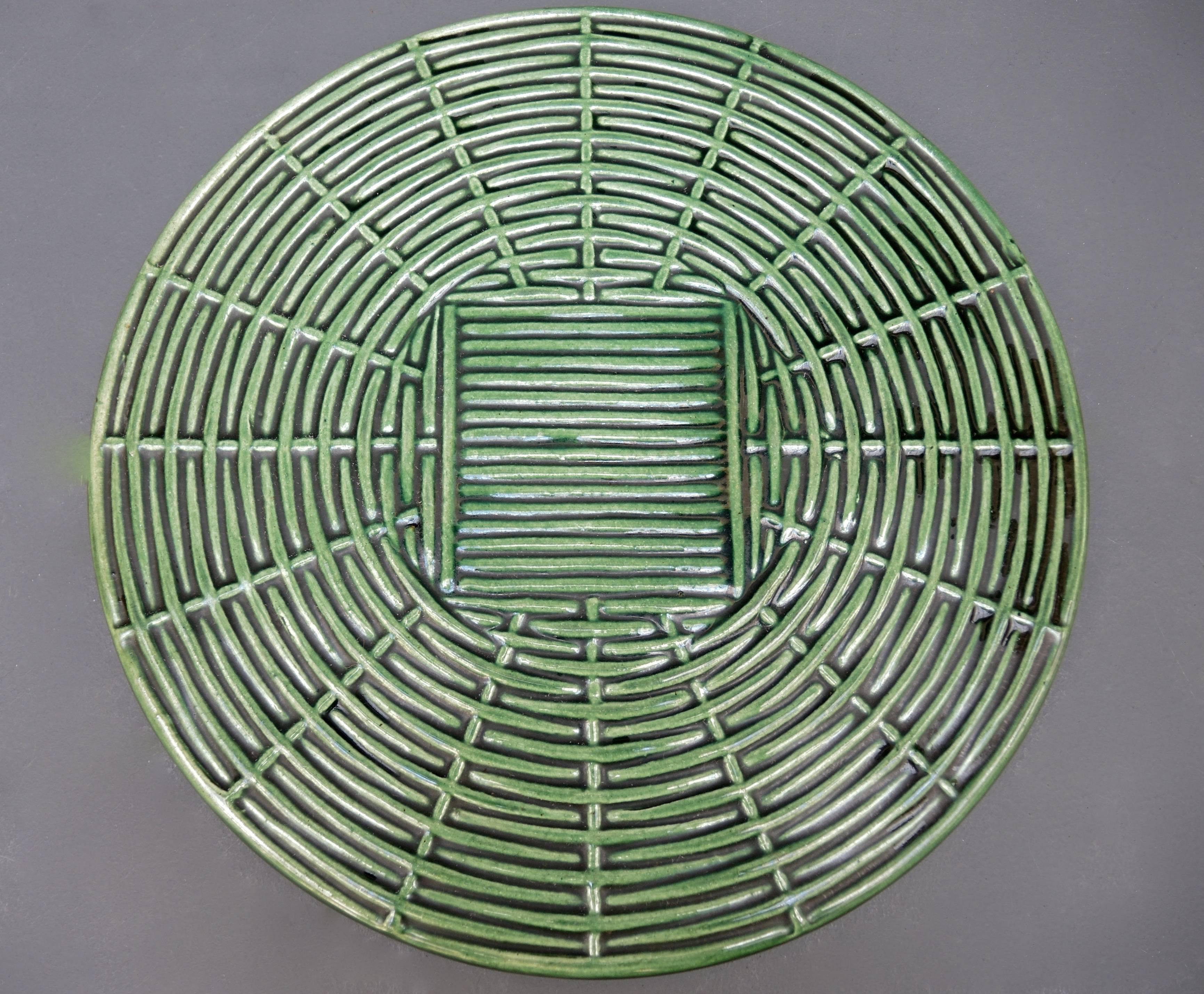 Beautiful woven form cheese or tart serving plate. Made of green tin glazed earthenware.
Decorative ceramic serving pieces are made by slip casting earthenware into a plaster mold. After several castings the details of the mold are lessened and