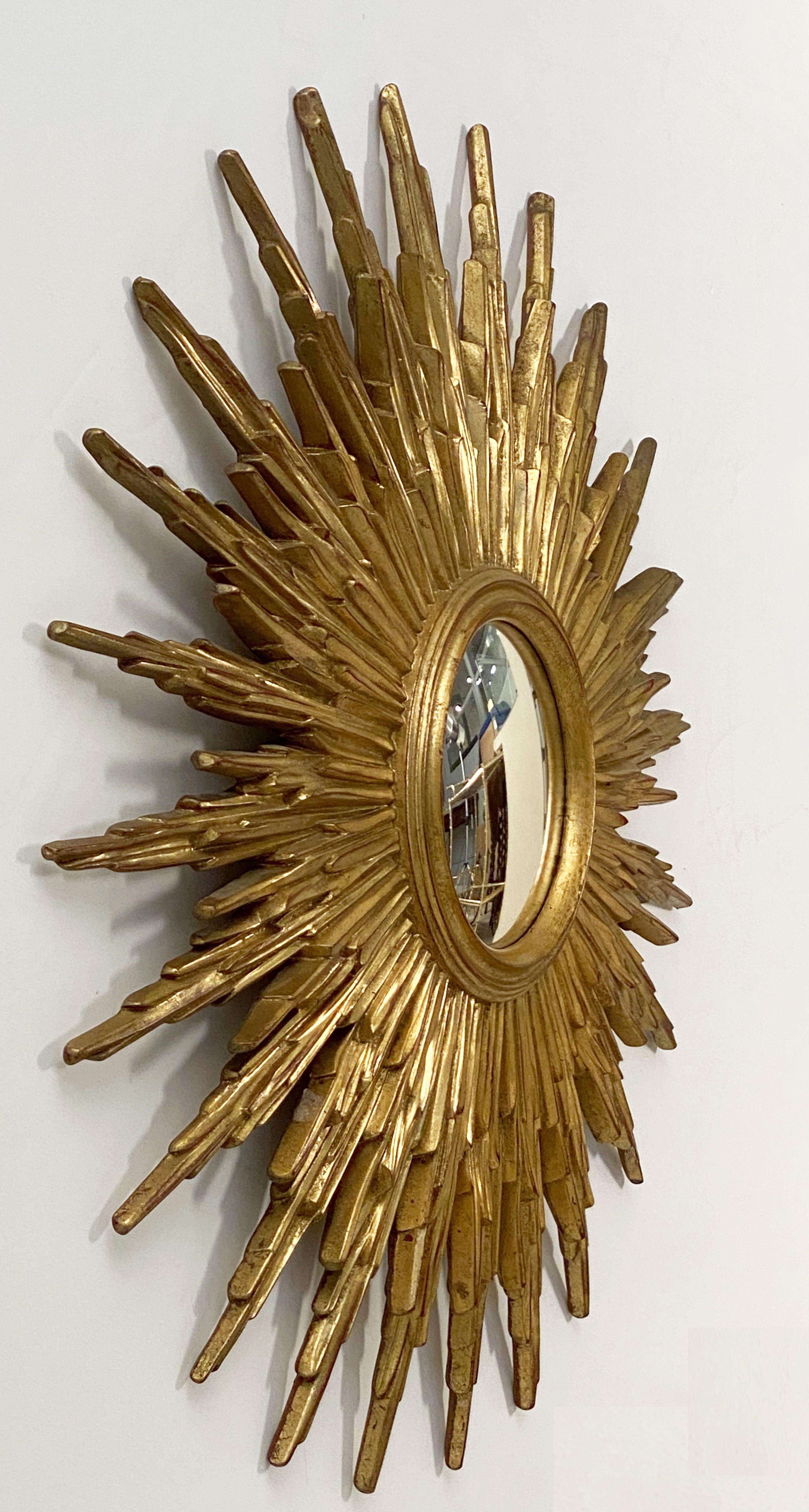 A lovely Belgian gilt sunburst (or starburst) mirror, 31 1/2 inches diameter, with a round, convex mirrored glass centre in moulded gilt resin frame.

 