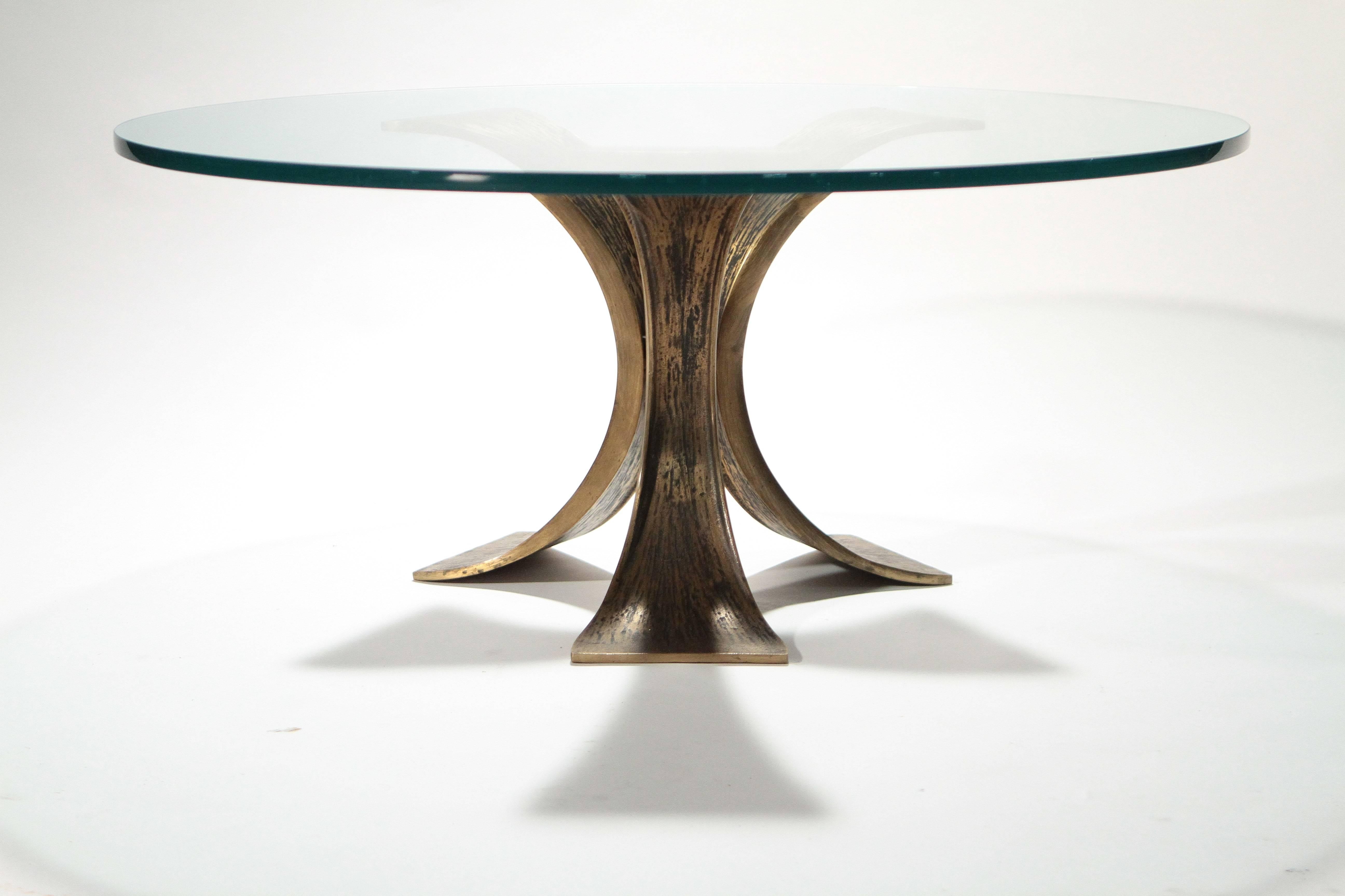 The natural shapes featured in this coffee table lend a solid, but wild feel to the piece. Heavy bronze feet are shaped and textured in a way that recalls the untamed beauty found in windswept wood or tree bark such ‘unrefined’ touches are