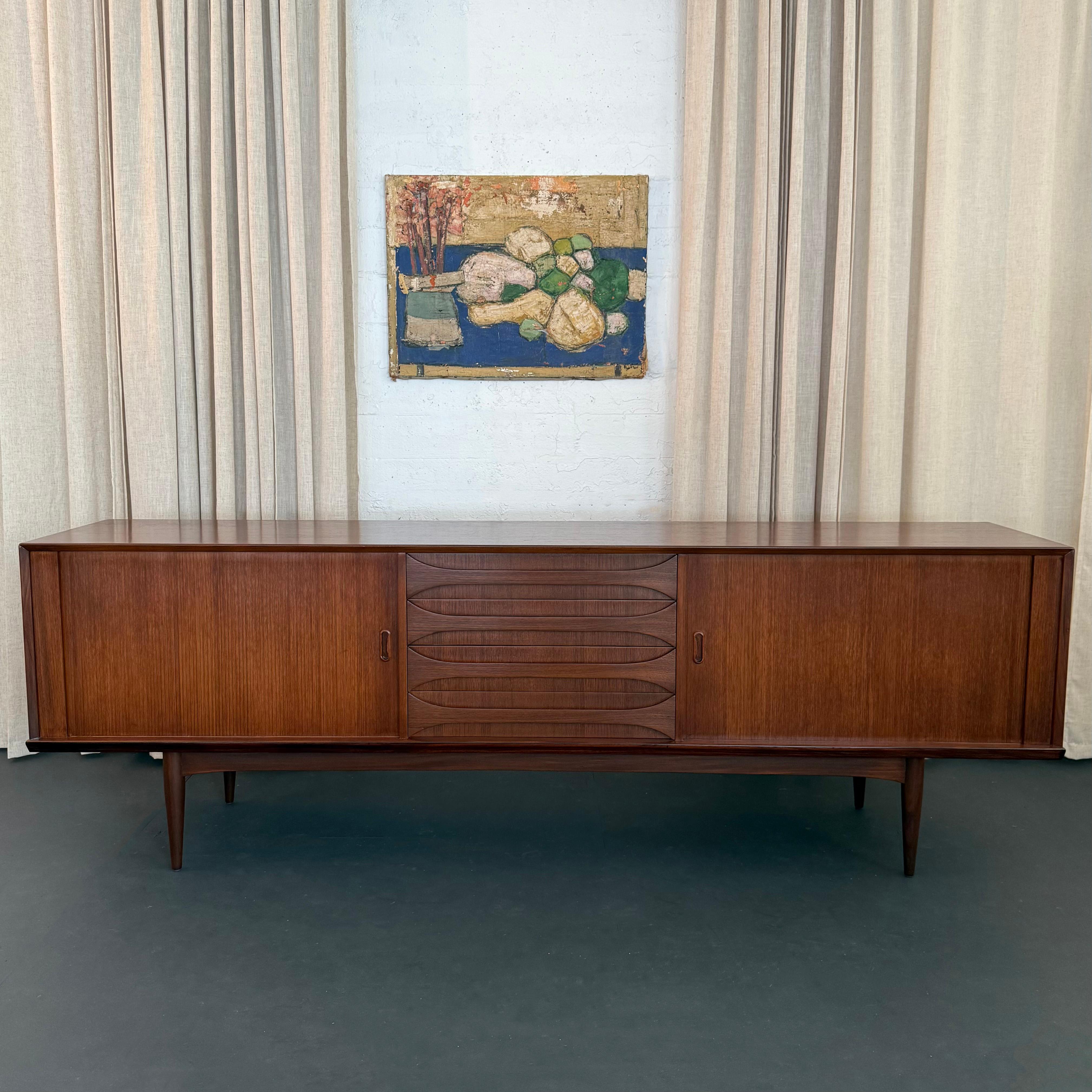 Ce superbe buffet crédence de haute qualité a été conçu par le designer belge Oswald Vermaercke et fabriqué par sa propre société V-Form vers 1959. Ce long buffet aux lignes épurées est fabriqué en teck magnifiquement grainé. Les tons riches et