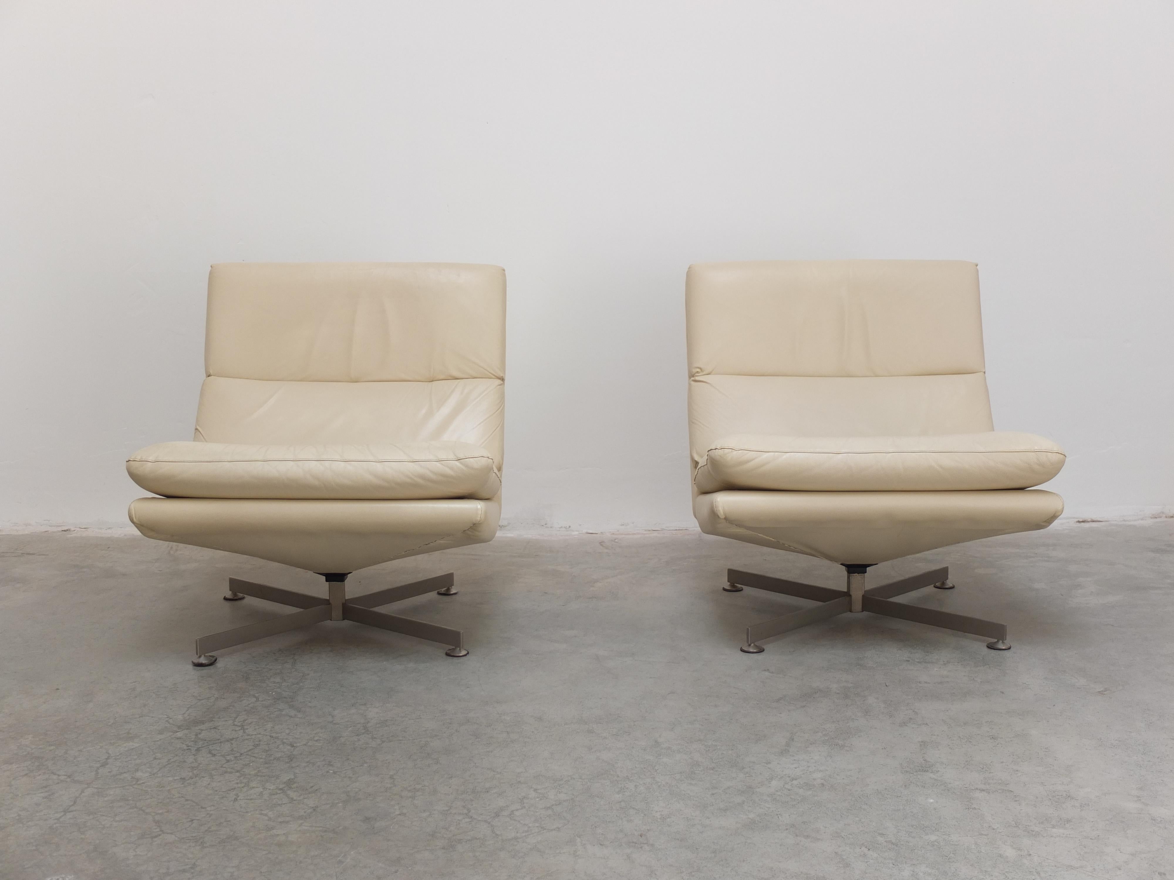 A rare pair of Belgian modernist lounge chairs designed by Georges Van Rijck for Beaufort during the 1960s. They feature a slim metal star-shaped base with a practical swivel function. All chairs are professionally reupholstered with a high quality