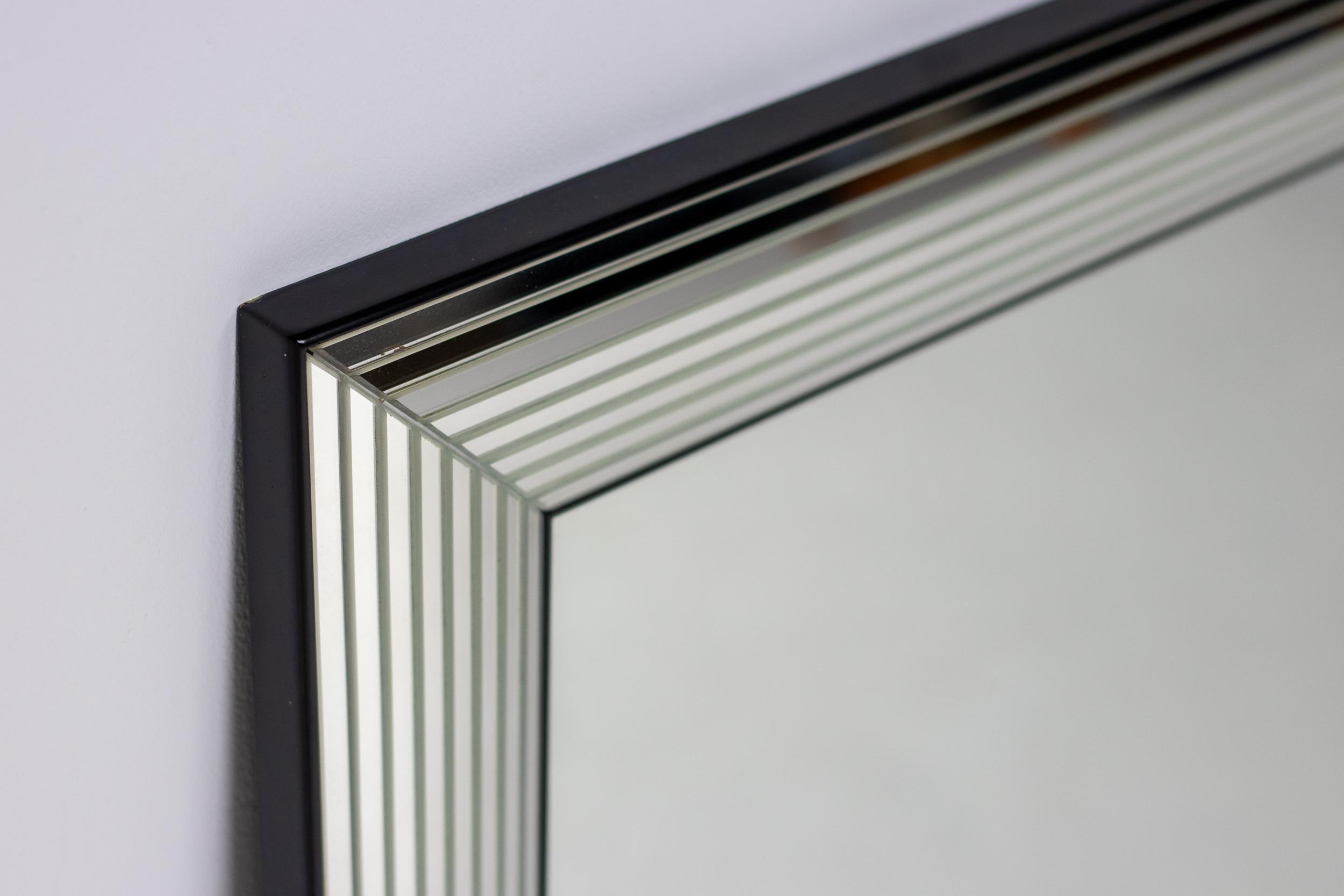 Miroir moderne de la fin du 20e siècle fabriqué en Belgique.
Le bord de ce miroir spectaculaire est composé de 8 couches de verre miroir.
Construction très solide avec dos en contreplaqué, utilisable verticalement ou horizontalement.