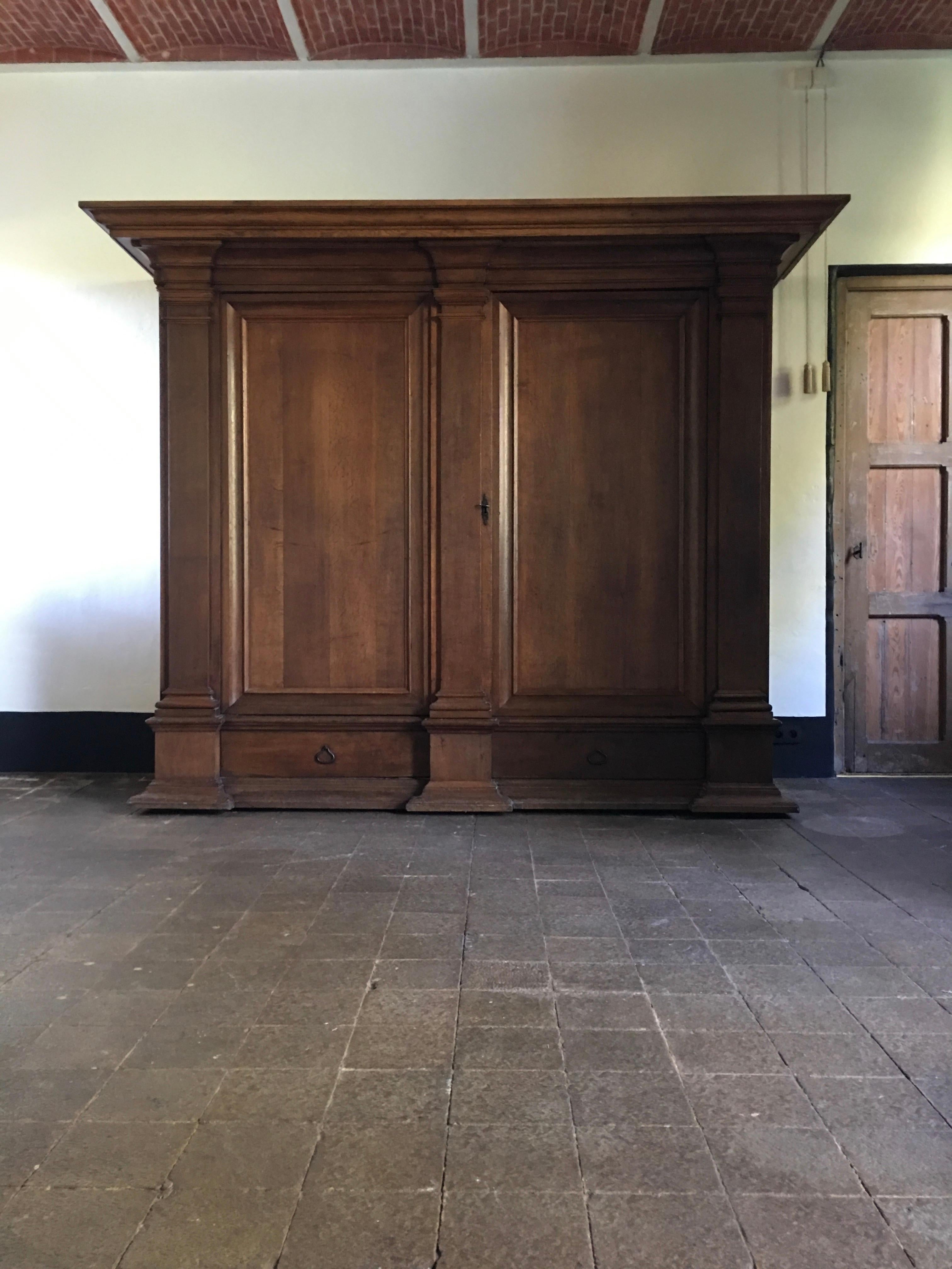 A near pair of oak neoclassical cupboards of elephantine dimensions. Each cupboard has two doors and two drawers and is entirely made of beautiful oak. They have an impressive provenance as they have been made for the Bruges Saint Saviour Cathedral