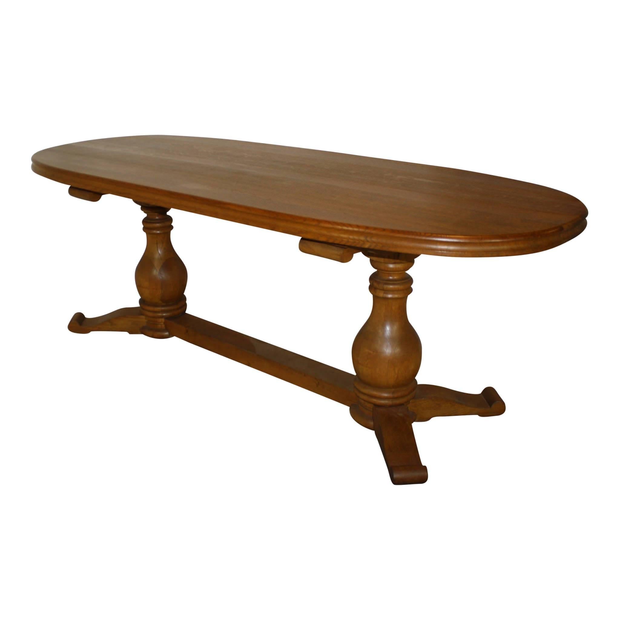 Crafted of oak, this oval Belgian table is ideal for casual or formal dining. The substantial, solid, two inch table top has the pattern of flecking and tight grain unique to quartersawn oak. The robust, double, pedestal table legs are united by a