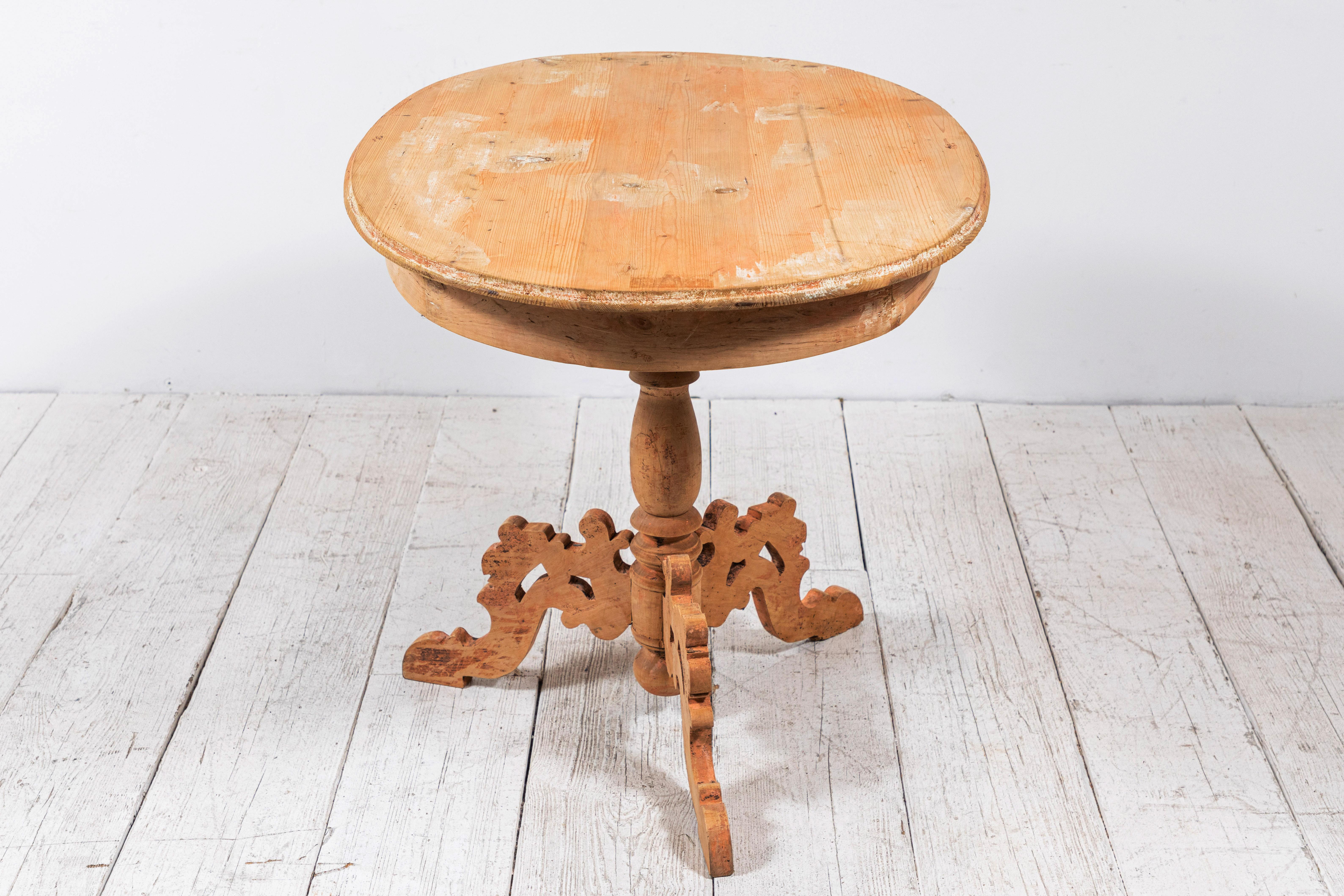 Natural Belgian wooden oval table standing on a delicately detailed three legged base.