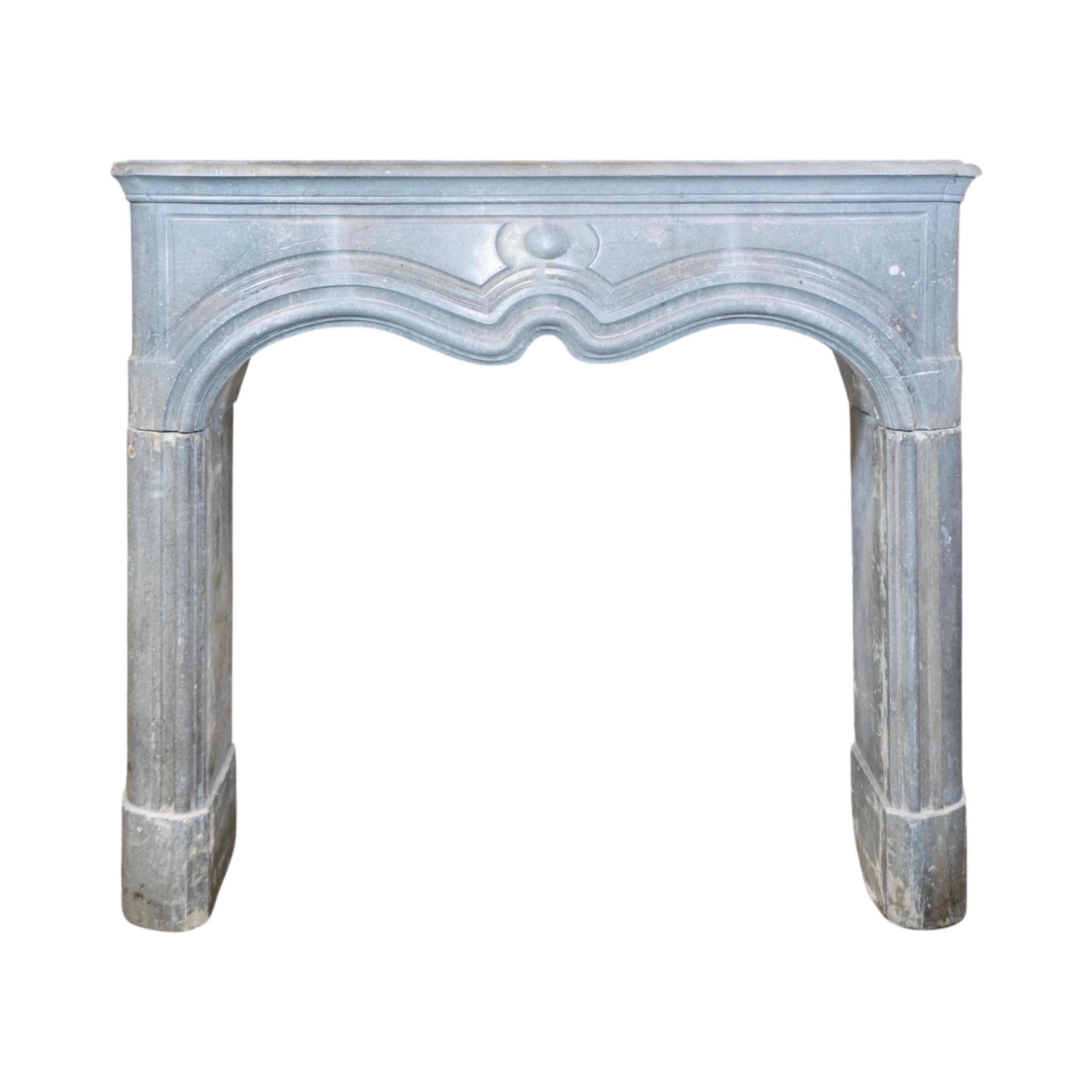 This elegant marble mantel is expertly crafted from Belgian limestone and boasts a polished Bluestone finish. Its intricate linework, inspired by the Louis XVI style, adds a touch of sophistication to any room. It originates from Belgium in the
