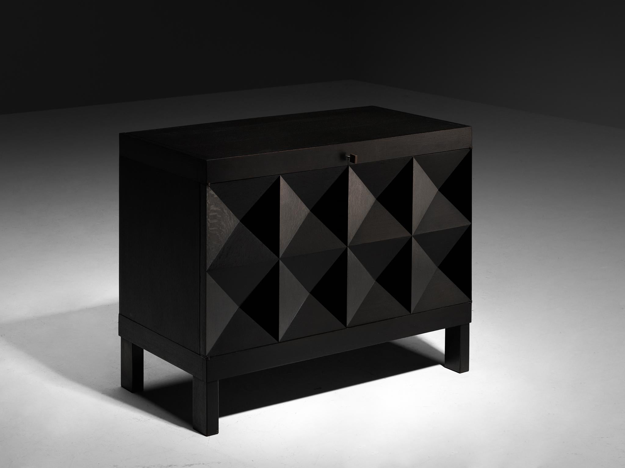 Sideboard, lacquered oak, Belgium, 1970s

This Belgian credenza showcases a meticulously crafted design, featuring a clear rhythm and flow that exudes harmony and balance. The carved pyramid front immediately catches the eye and is the signature for