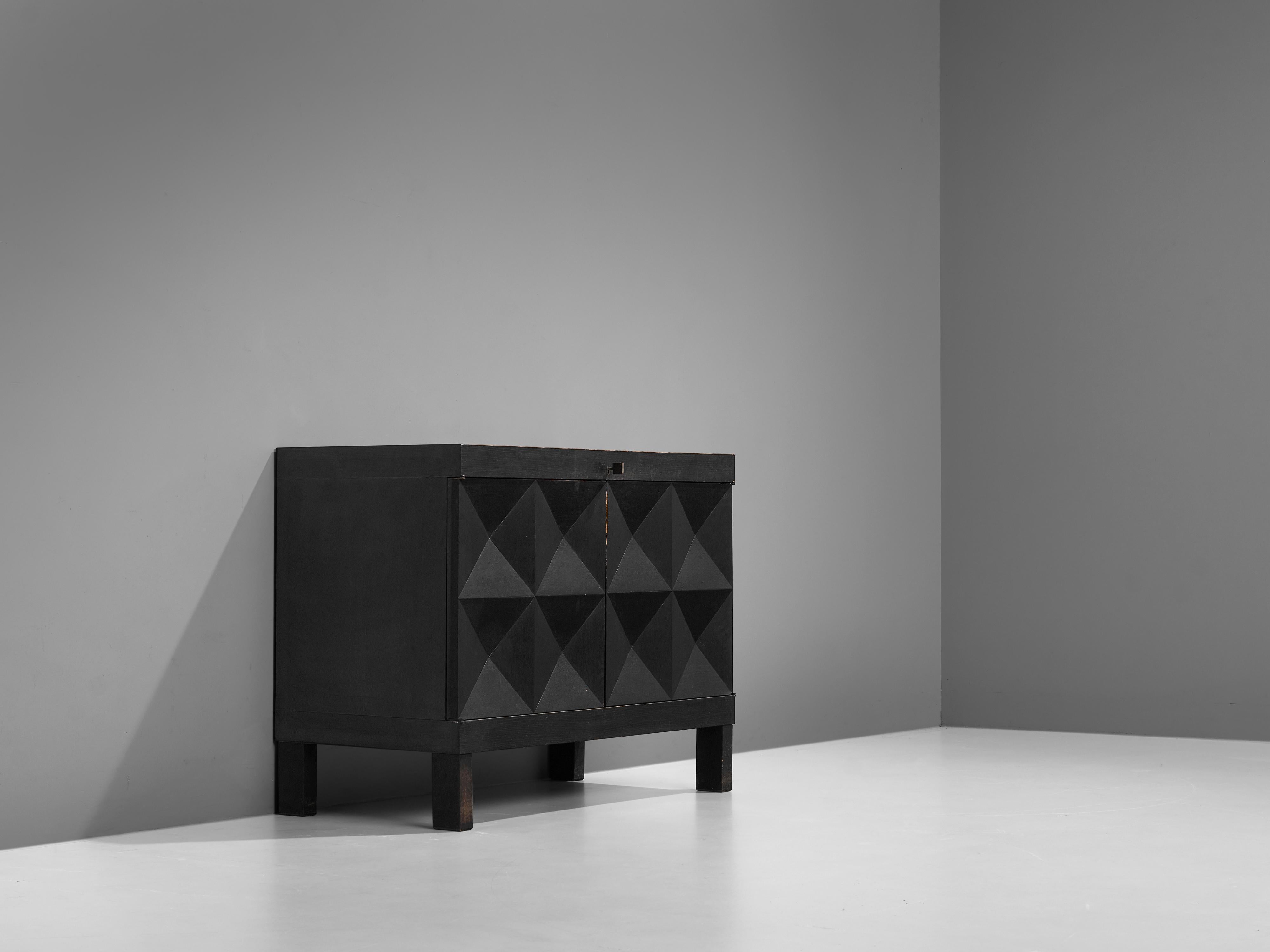 Belgian sideboard, stained oak, Belgium, 1970s. 

This small sideboard with geometric doors is attributed to De Coene. The credenza shows a pyramid like pattern on its doors. The squares on the front are each divided in four quarters and the chest