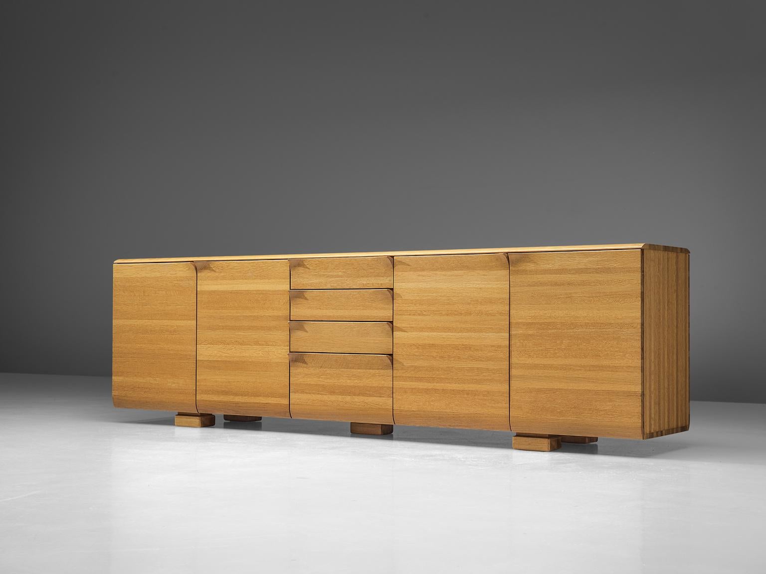 Van Den Berghe, Pauvers, sideboard, oak, Belgium, 1970s.

This Minimalist Belgian credenza features striking handles. The doors flow over in the handles, which bent like a page of paper. The credenza offers plenty of storage space, containing two