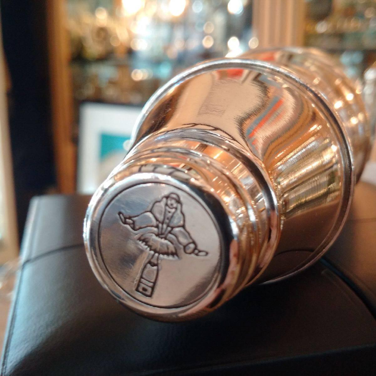A notably unusual commemorative silver cocktail shaker, the Modernist shape created as a replica of the famous Spa Reine branded bottle of 1971. With its distinctive sloped neck and ribbed lower body, the stamped cap is engraved with the famous Jean