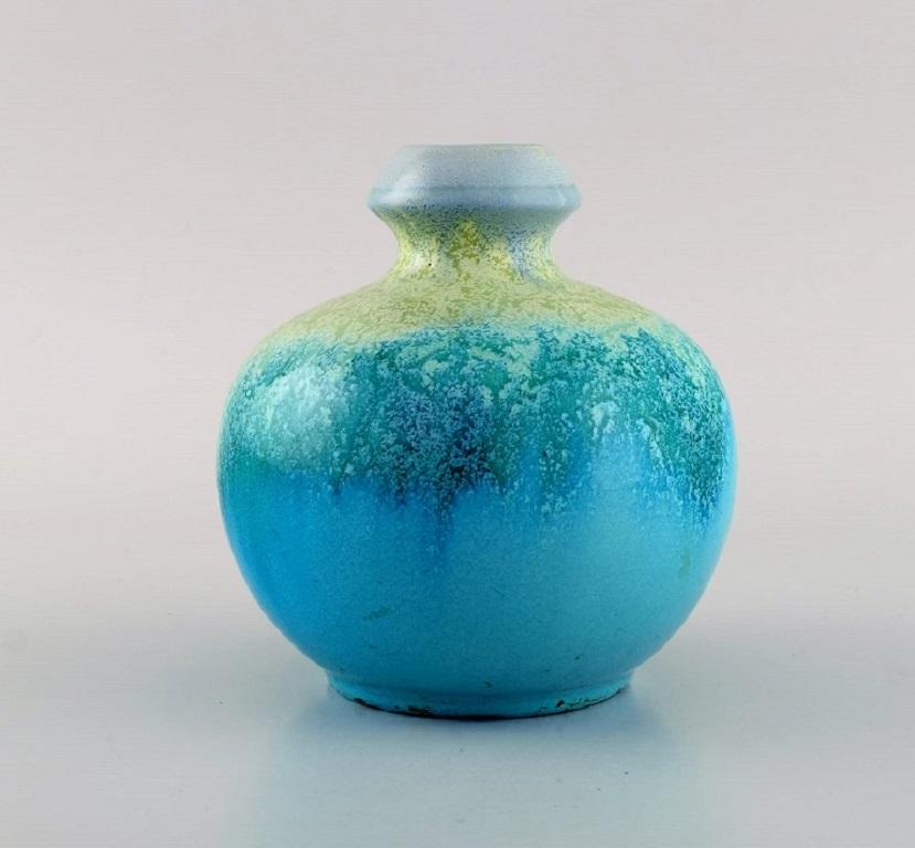 Belgian studio ceramicist. Round vase in glazed ceramics. Beautiful crystal glaze turquoise shades. 1960s / 70s.
Measures: 13 x 12,5 cm.
In excellent condition.
Stamped.