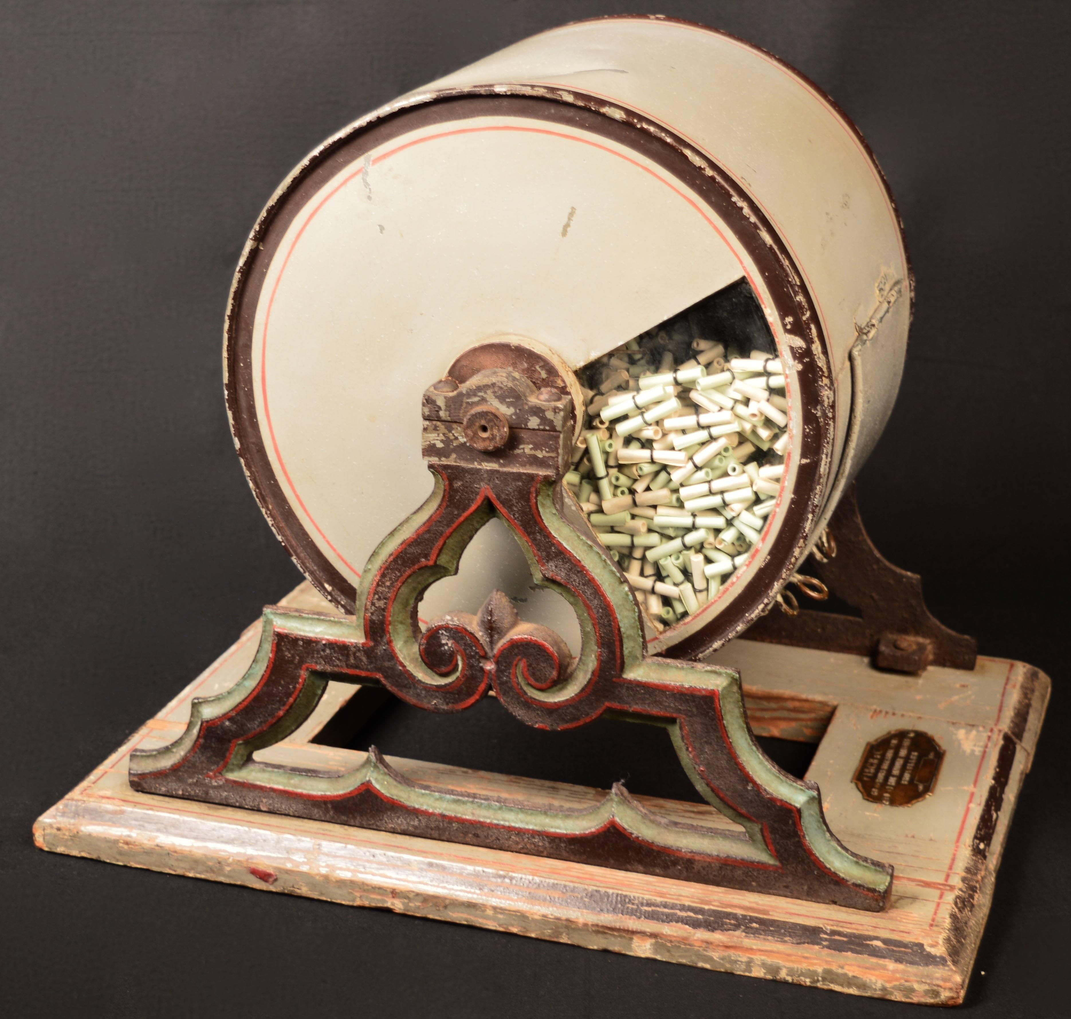 Belgian Raffle tosser filled with loan debt papers, circa 1910.
Made of tole (painted tin) on a wood base with brass plaque. Completely original. This raffle tosser or 