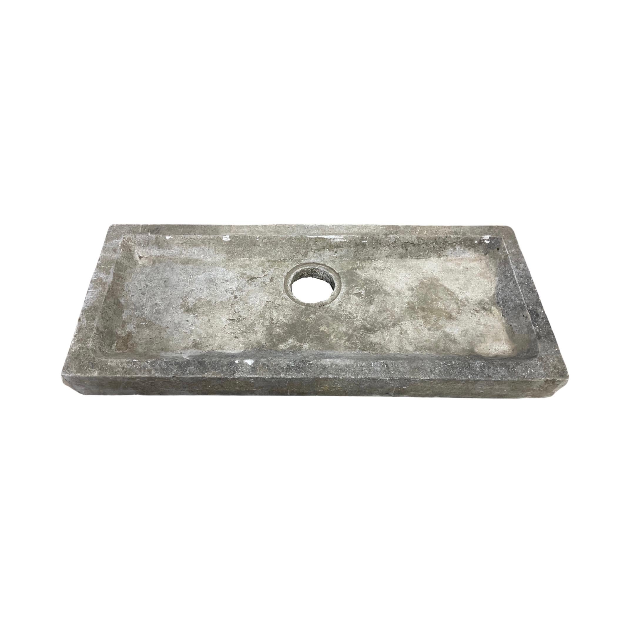 This Belgium Bluestone Sink is a unique piece. Crafted in the 18th century, it has a trough-style design of length and a circle carved for drainage. Its handmade details add an elegant design to any space.