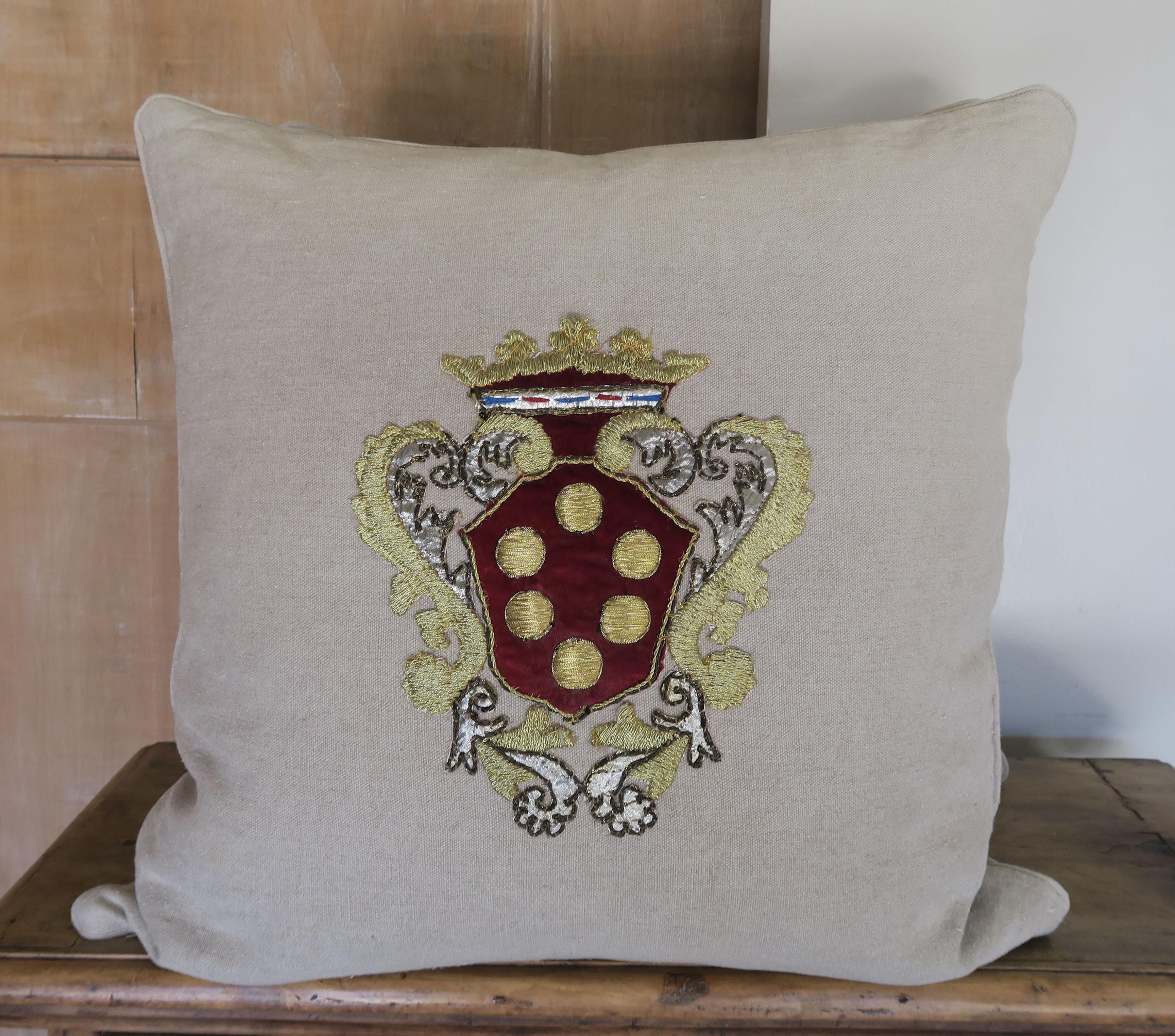 Custom pair of natural linen pillows with a metallic and velvet Italian shield appliqued on the fronts of both pillows. Down inserts, zipper closures.