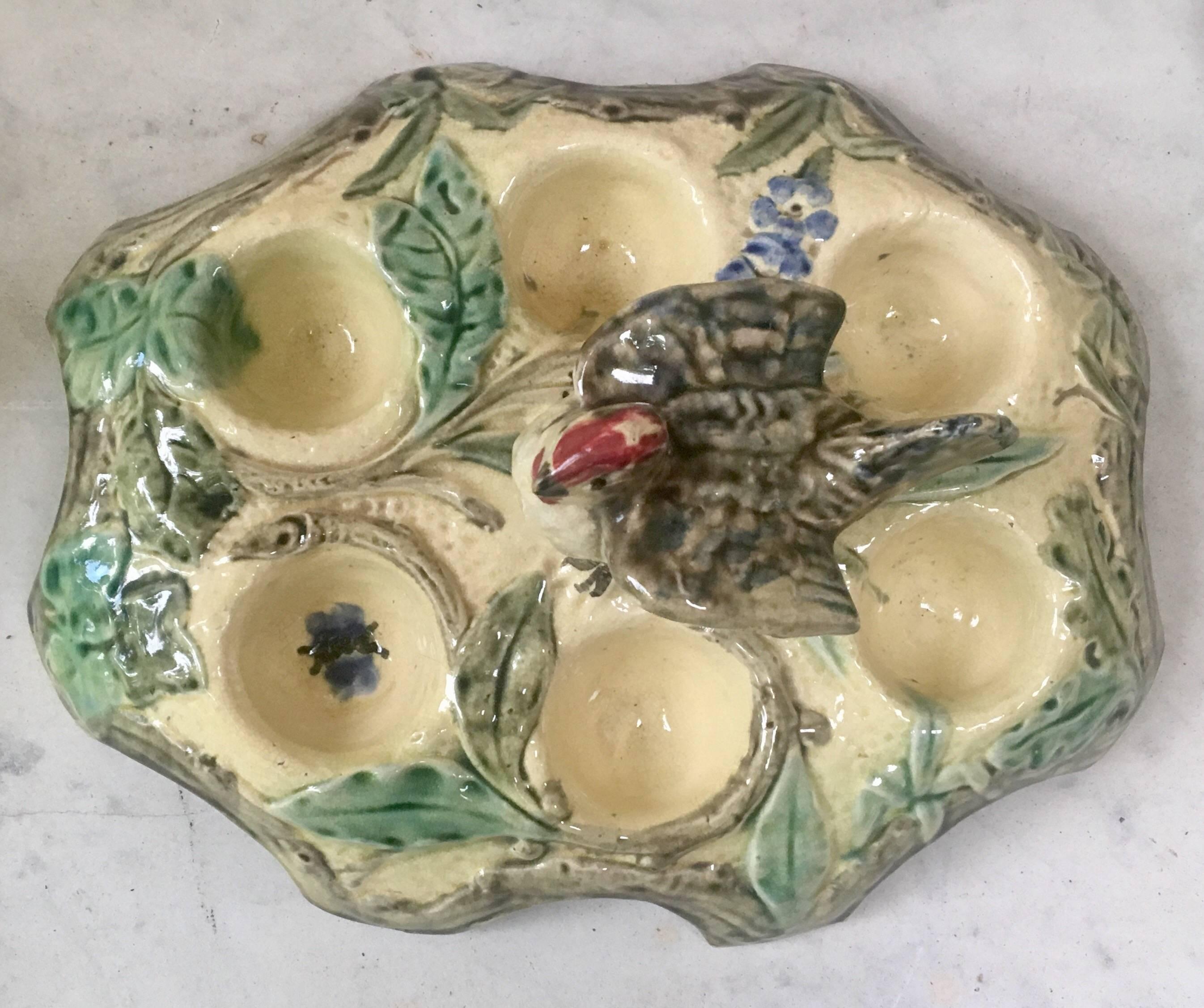 Belgium Majolica egg plate with bird handle for six eggs decorated with flowers, butterfly and leaves, circa 1880.