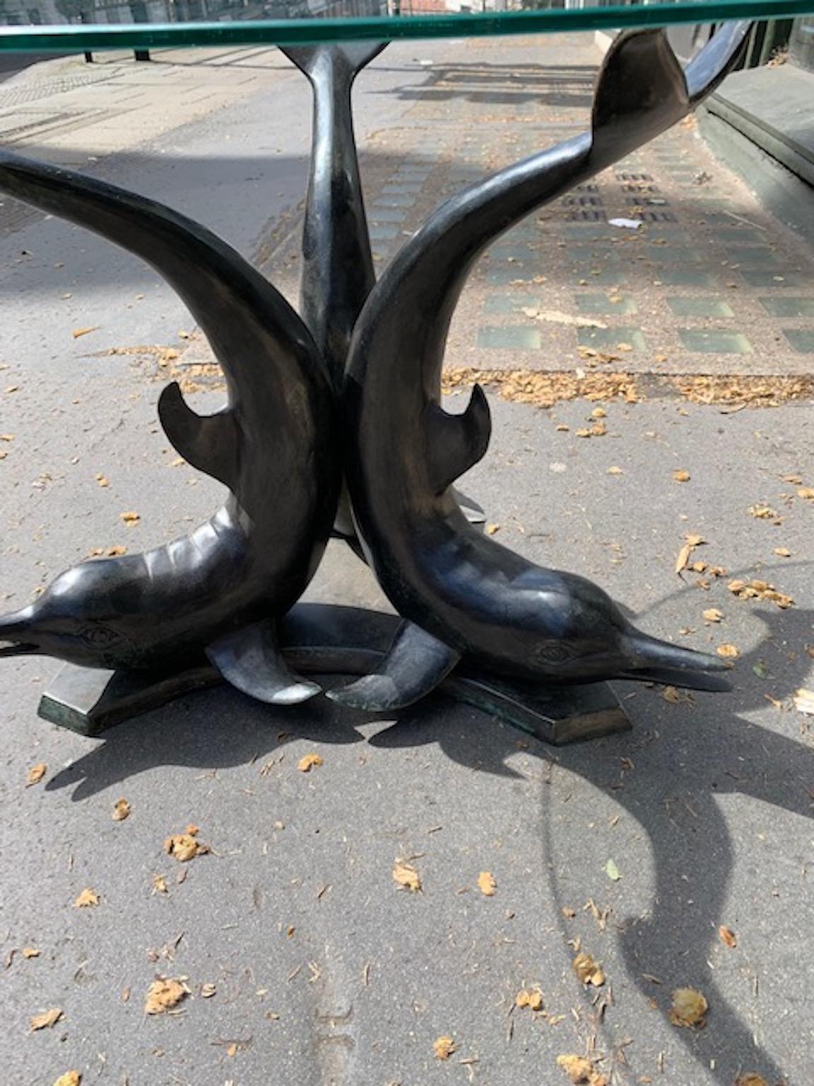 A solid cast bronze finish coffee table with a clear glass top.