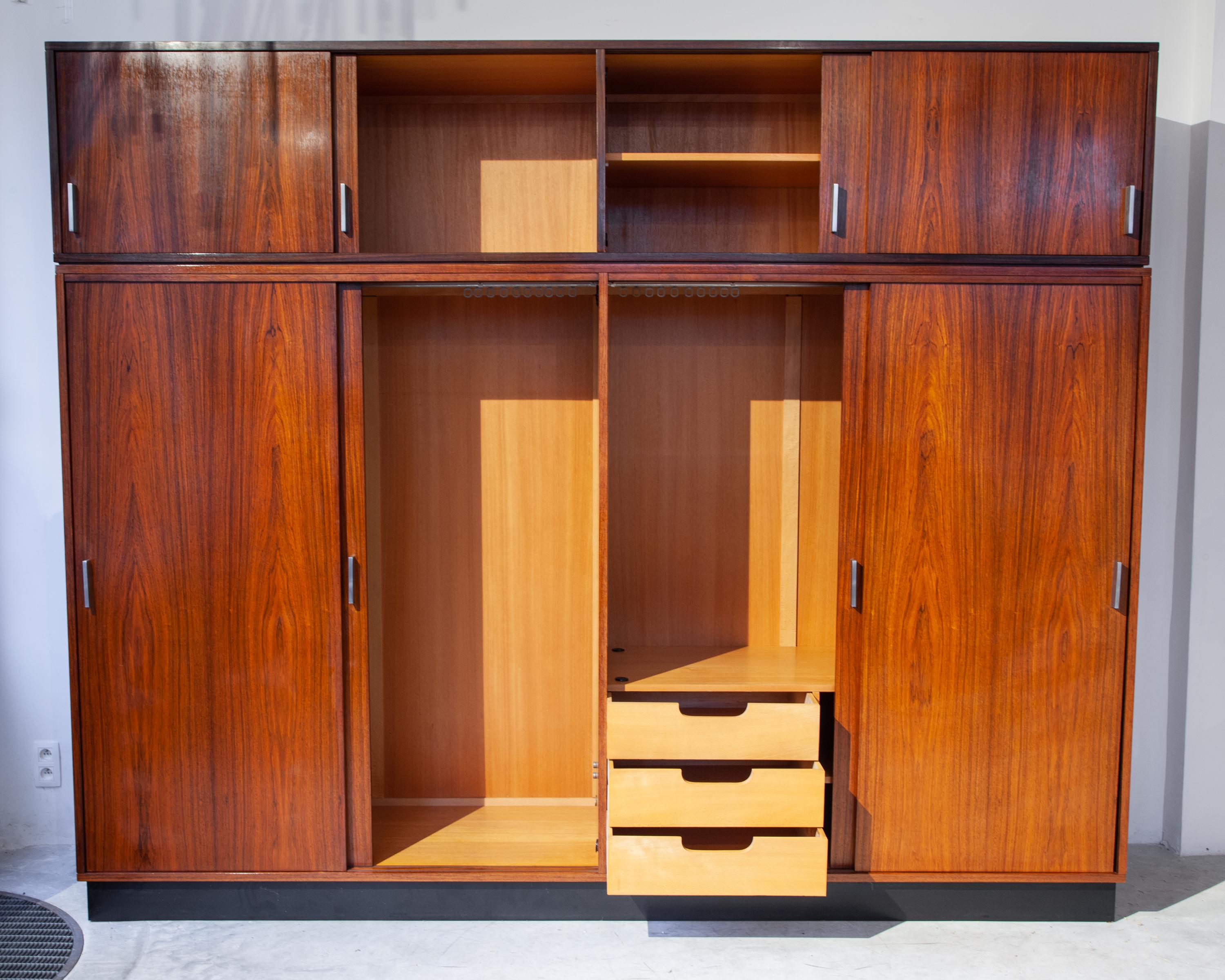 Handcrafted walnut wardrobe a beautiful masterpiece by Alfred Hendrickx for Belform. Two hanging closet compartments, three drawers and an upper cabinet with shelves. The doors have stylish silver handles and slide smoothly on thier tracks. Can be