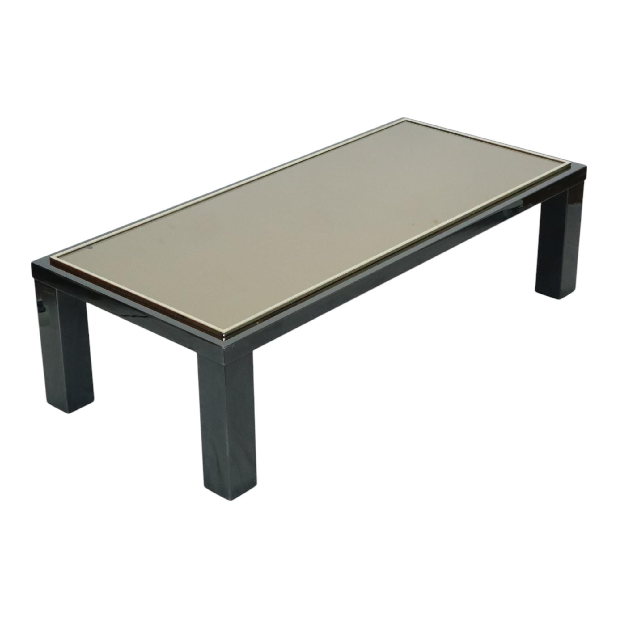 Vintage rectangular coffee table with sleek design, made of black lacquered metal and a thick table top made of smoked glass with a 23 carat gold edge, Hollywood Regency design by Roger van Hevel for Belgochrom, Belgium 1970s.

Timeless design and