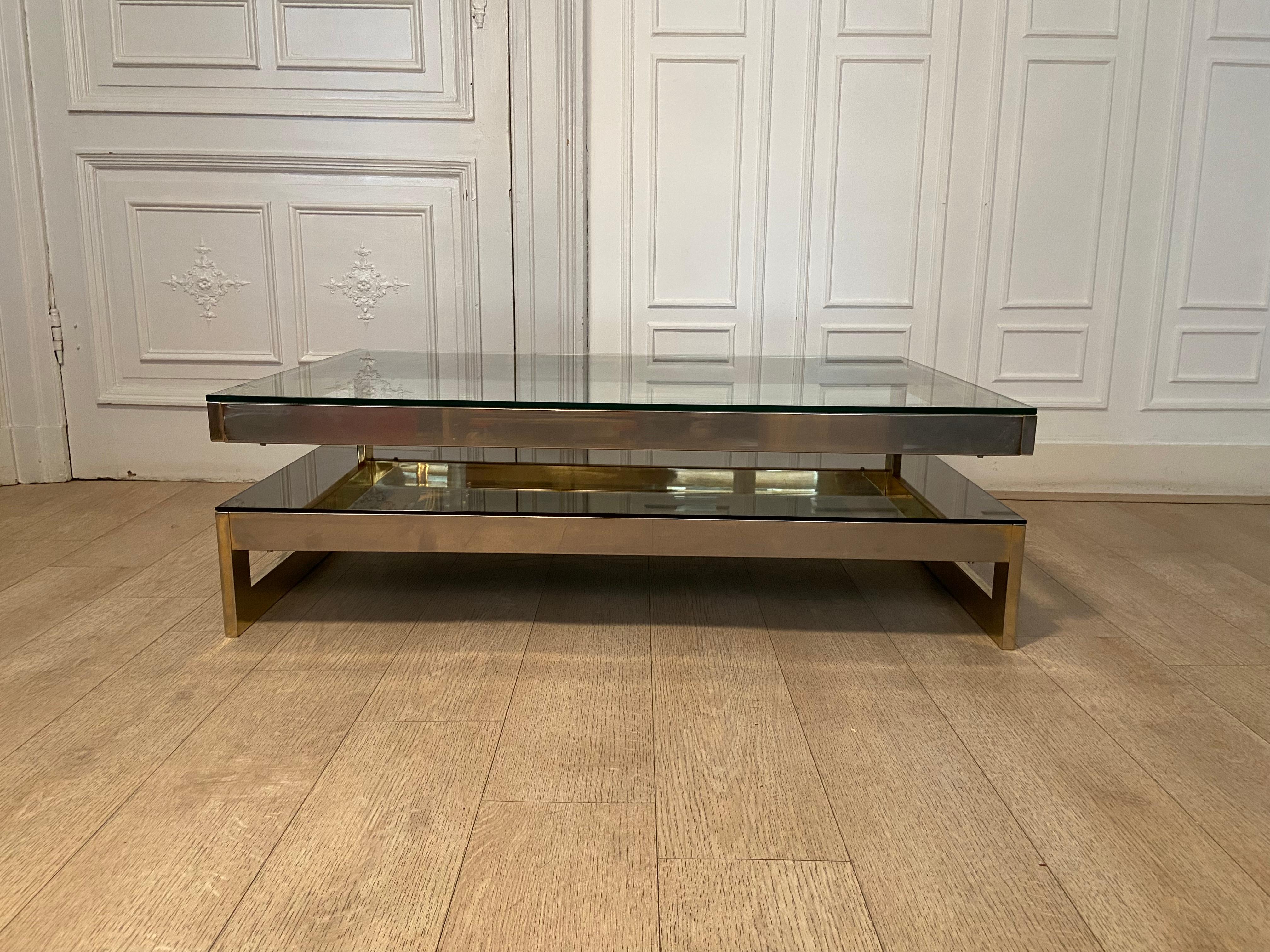 Famous g-shaped coffee table from the Belgian manufacture belgo chrom and produced in the 70s. Metal structure gilded with fine 23 carat gold. Lower shelf in bronze mirror and upper shelf in transparent glass.