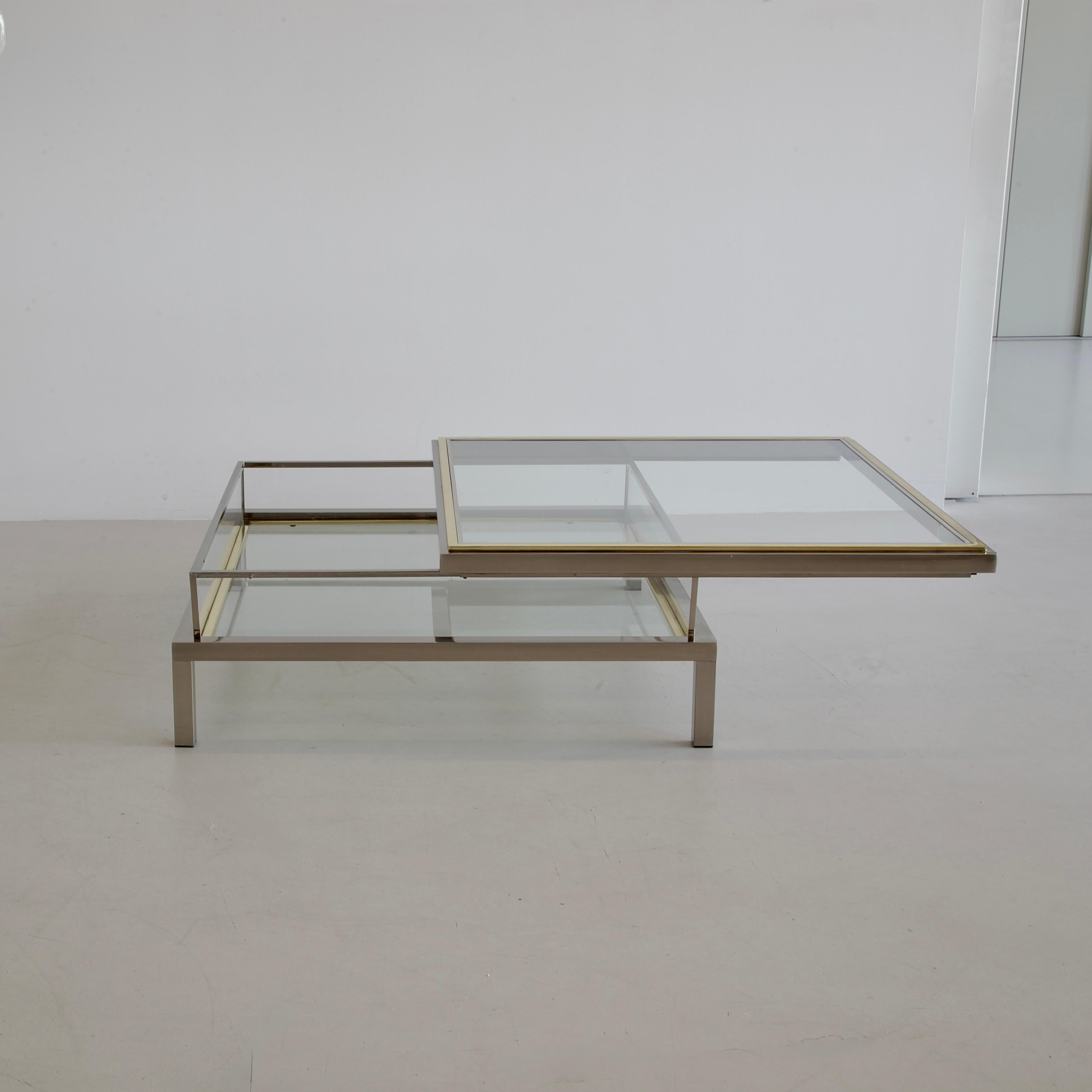 Coffee Table with sliding top. Belgium, Belgo Chrom, 1970s.

A Coffee Table with a polished steel frame and a sliding top in chrome and brass-coloured metal, it has a clear glass top and a glass base. The top slides open to a storage space to
