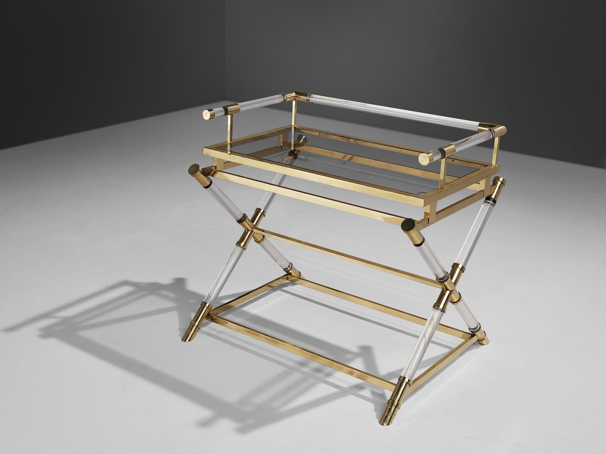 Belgo Chrom, serving table, brass, lucite, glass, Belgium, 1980s. 

This sculptural serving table features a smoked glass table top. This top is aligned with a geometrical  double brass frame that rests on a x-leg base executed in clear lucite.