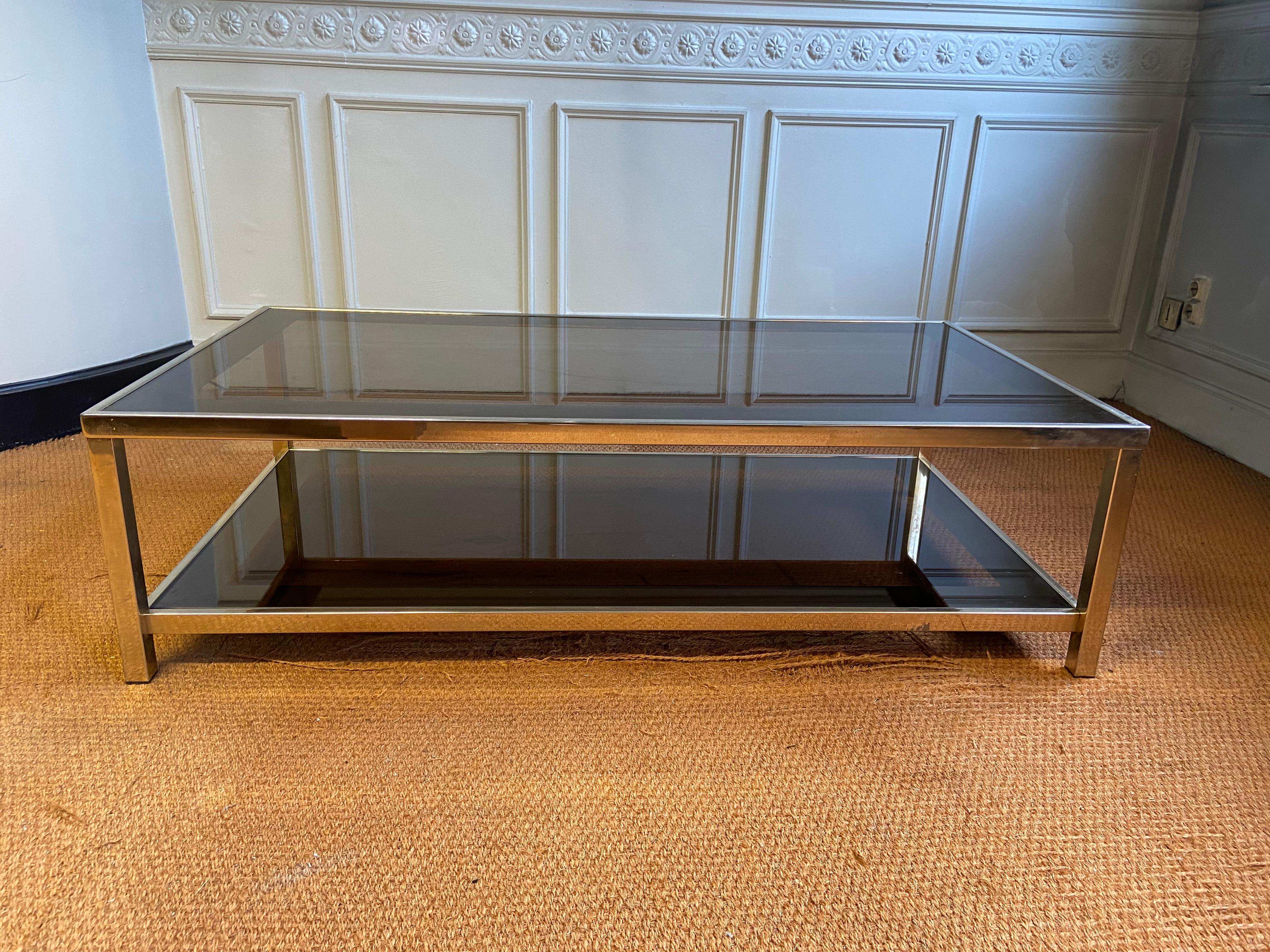 Coffee table produced by belgo chrom in belgium in the 70s. Structure in metal gilded with fine 23 carat gold. Two smoked glass tops with bronze mirror edges. Used condition consistent with the age of the piece.