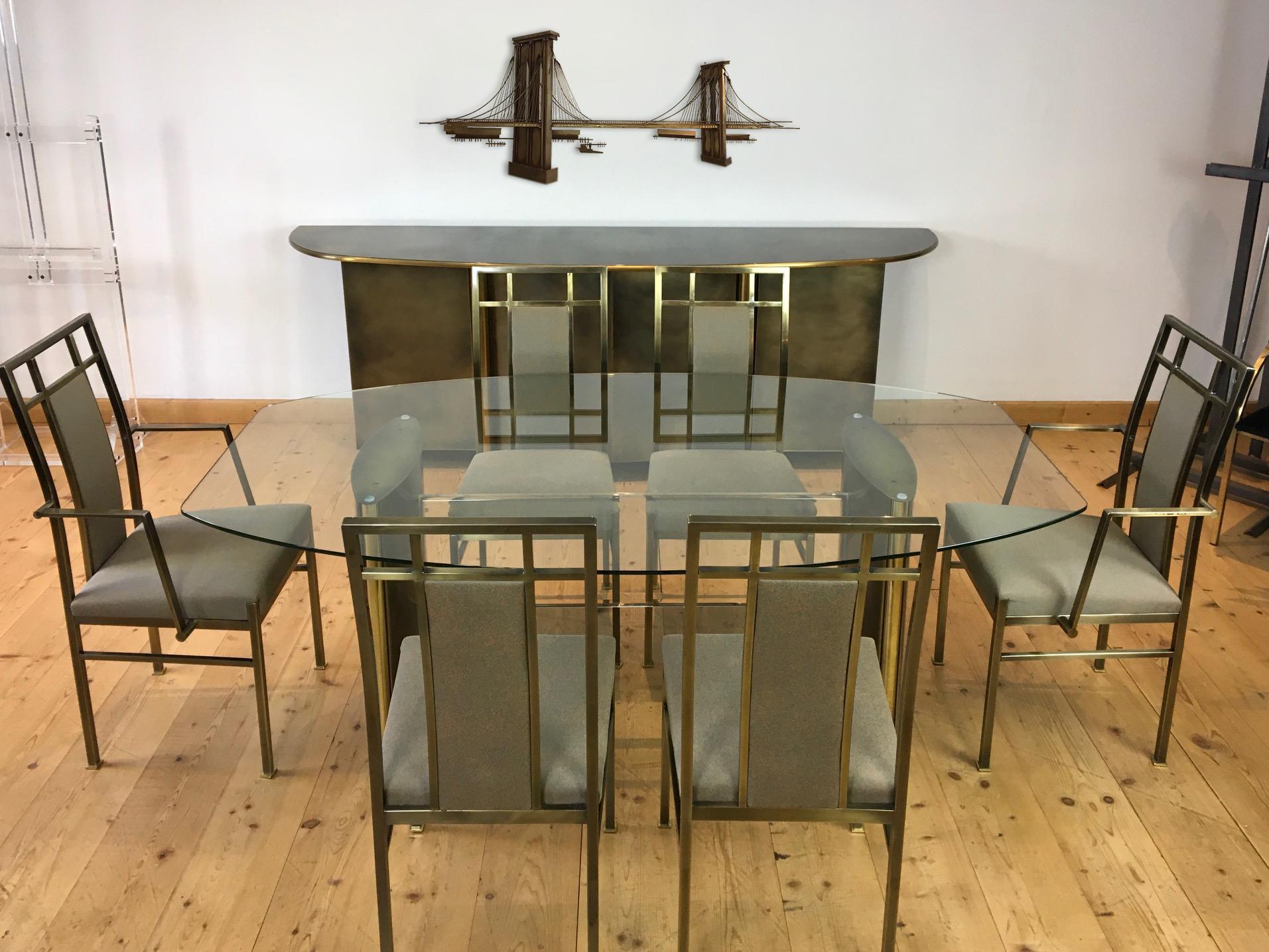Belgo Chrome dining room set consisting of a dining room table with 6 chairs. 
This stylish Hollywood Regency set has a dining room table with 2 bronze patinated steel legs which are connected by a lucite intermediate piece and a thick glass top.
