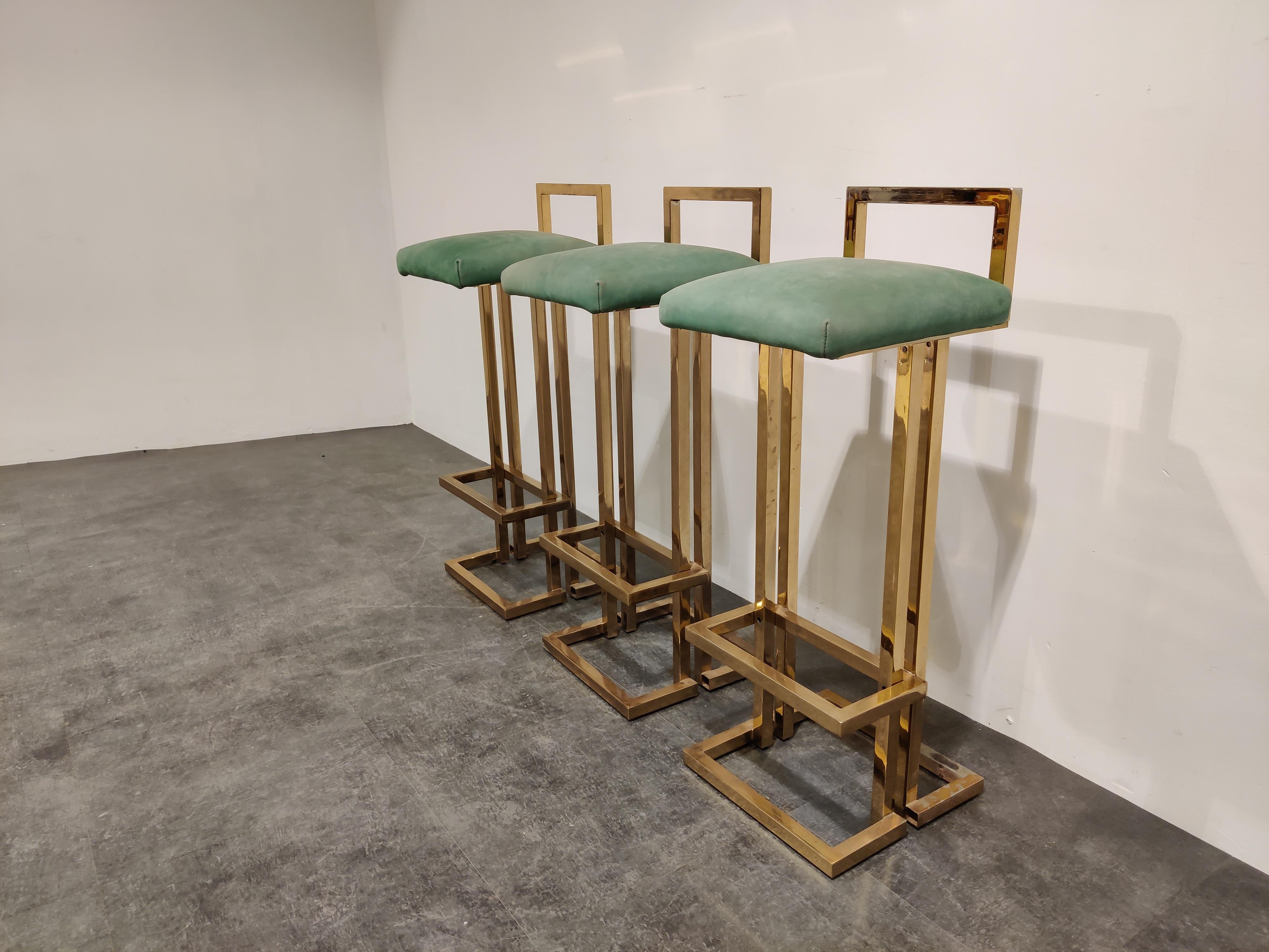 Beautiful brass bar stools by Belgochrom.

Beautiful timeless design with a luxury appeal.

They have their original green Alcan Tara upholstery.

Condition: Two stools are in good original condition
- The third stools have faded brass on the