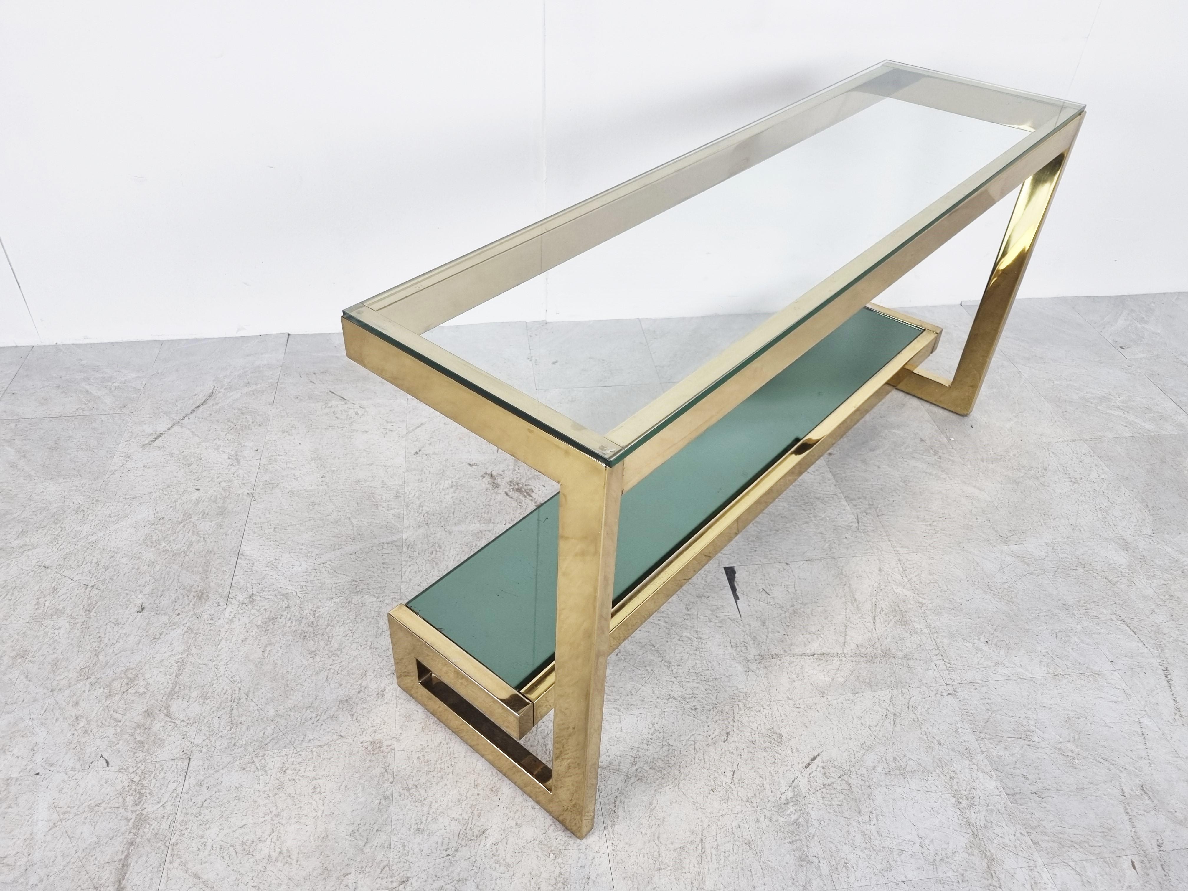 23kt gold layered 'G'-shaped console table produced by Belgochrom.

The table has mirrored and clear glass tops

Original condition with some wear on the brass, condition as picture. The glass is in good condition. Over the item look very