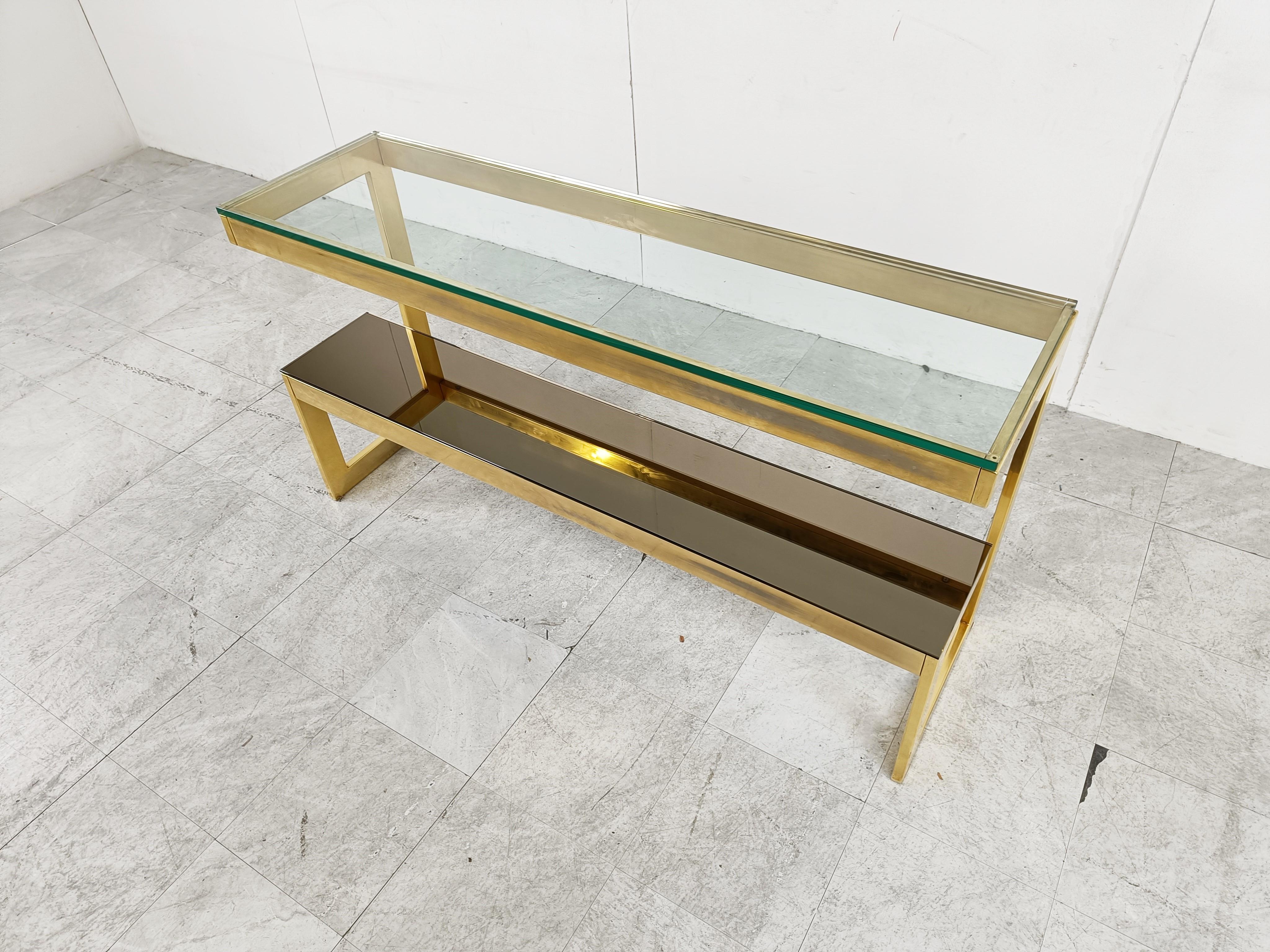 23kt Gold layered 'G'-shaped console table produced by Belgochrom.

The table has mirrored and clear glass tops

Original condition with some wear on the brass, condition as picture. The glass is in good condition. Over the item look very