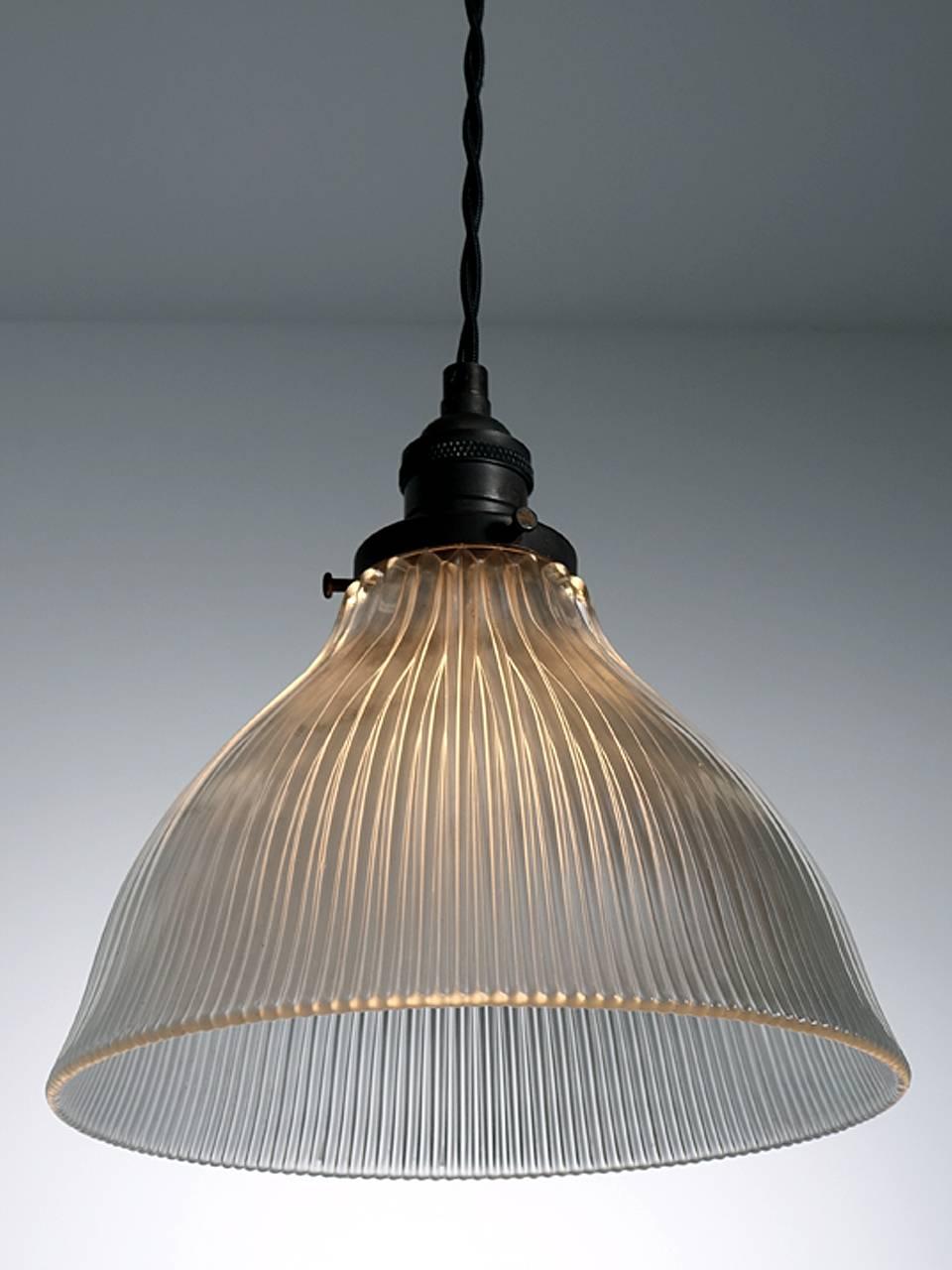 These are nice Holophane pendants with a unique softly curves profile. This shape gives it more of a residential feel than the standard prismatic glass. This type of glass gives off the best quality light. The glass is colorless and the look can