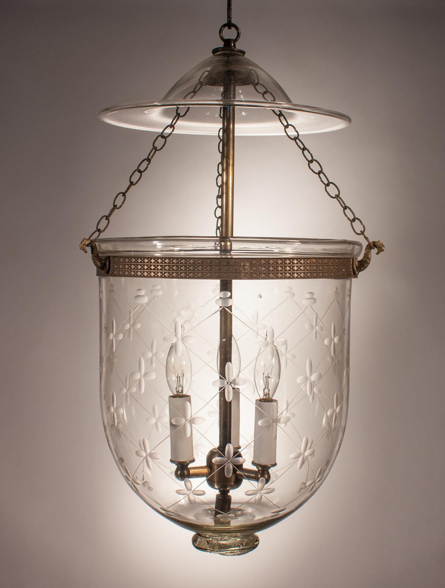 An antique bell jar lantern with lovely form and an etched climbing trellis design. This circa 1890 handblown glass pendant is in very good condition and features its original smoke bell, chains, and a unique pontil. The brass band, which has a nice