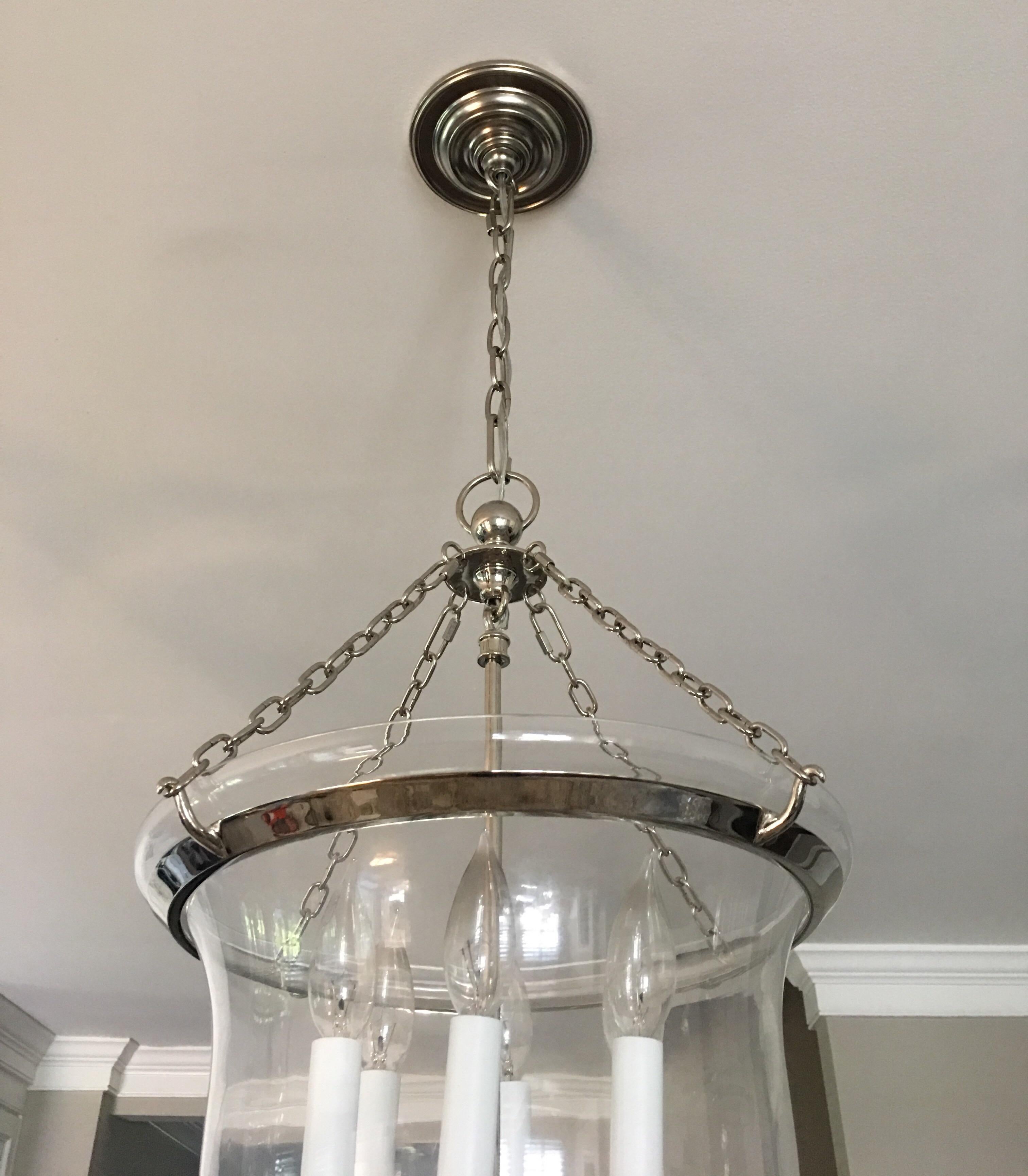 Classic bell jar chandelier light fixture by Chapman & Myers. Polished Nickel finish with removable clear glass bell jar. Six candle base bulbs. 60 watts per socket. Two lanterns available for purchase. 

Fixture is 21 Inches long from bottom of