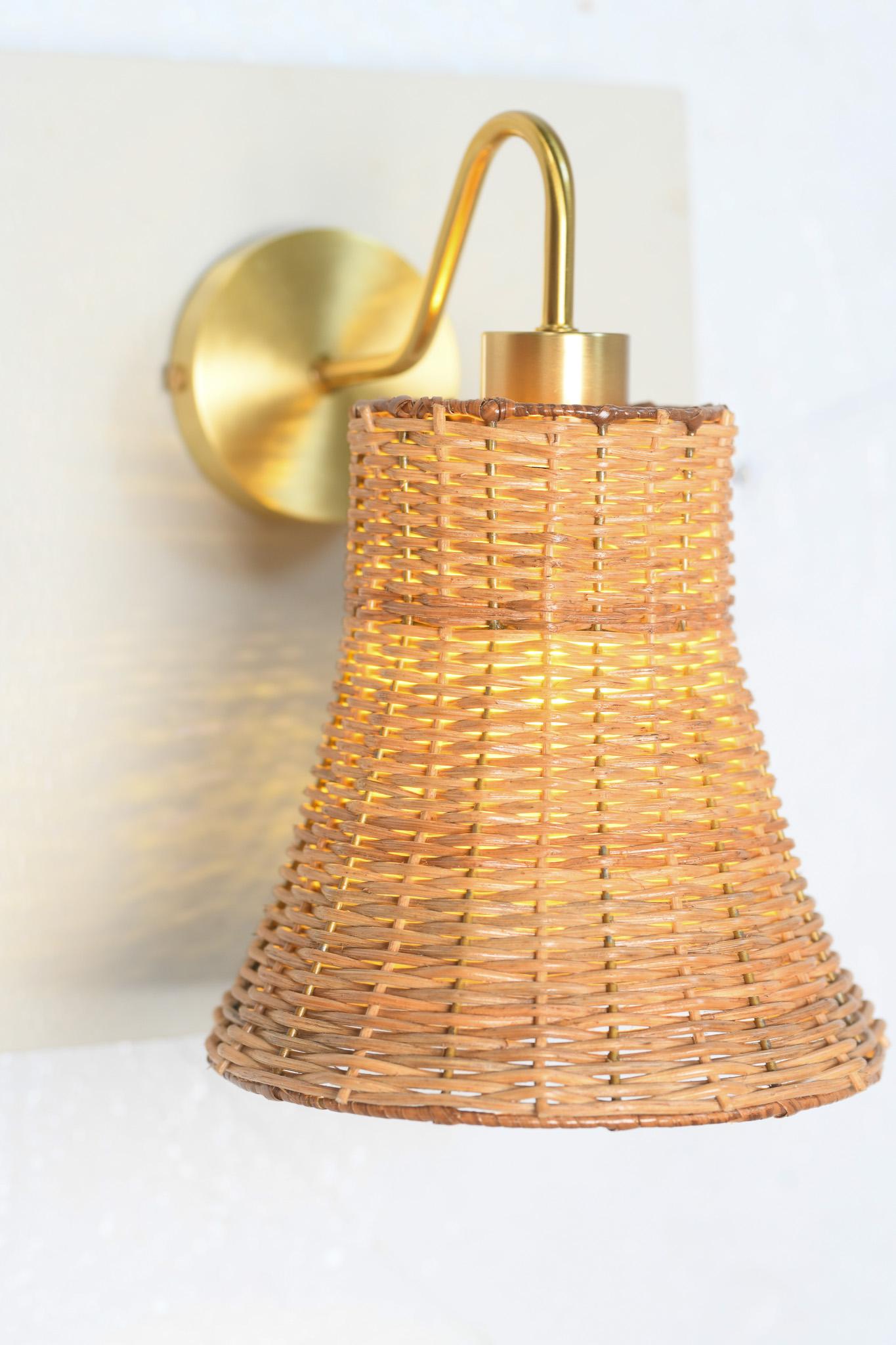 Inspiriert vom sanften Rhythmus der Natur und der zeitlosen Schönheit des handgefertigten Designs, fängt die glockenförmige Wandleuchte aus Messing und Rattan von Rattanology die Essenz organischer Raffinesse ein.

Jedes Stück beginnt mit