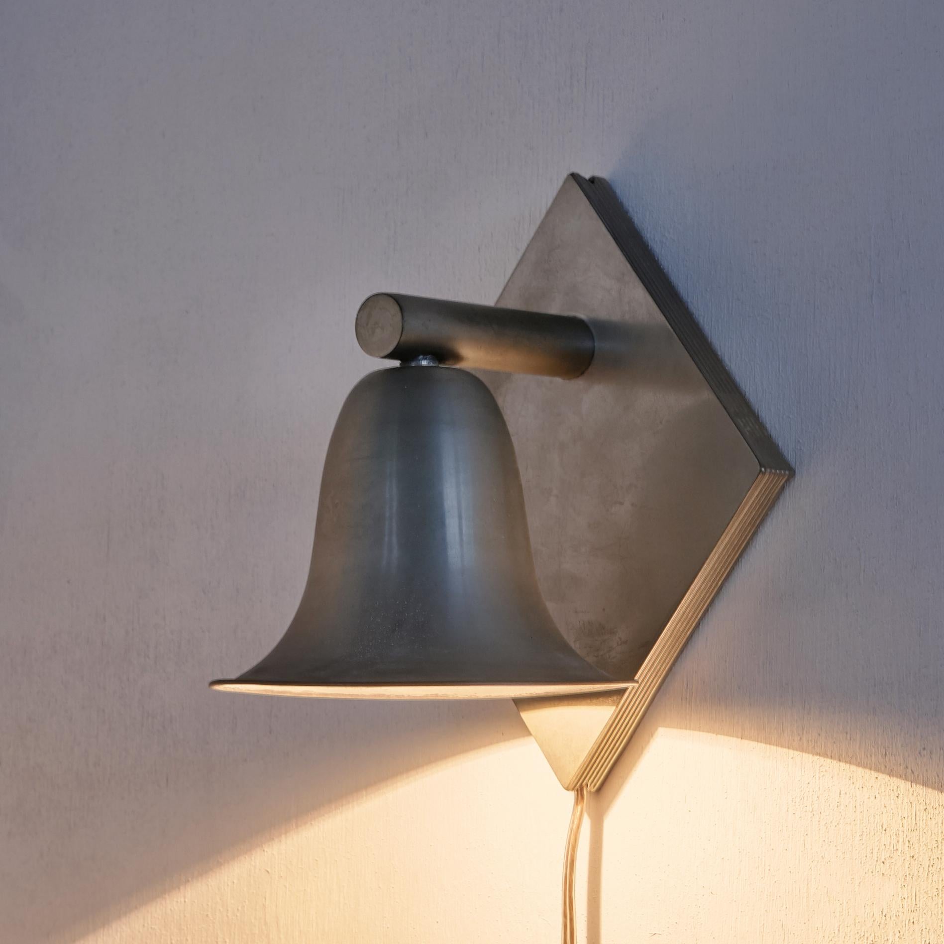 Bell shaped wall sconce by Gispen. Nickel plated and nicely patinated on the inside and outside.

The 'bell' is hanging upside down here, but can also be positioned the other way round to create an uplighting sconce. 

In great vintage working