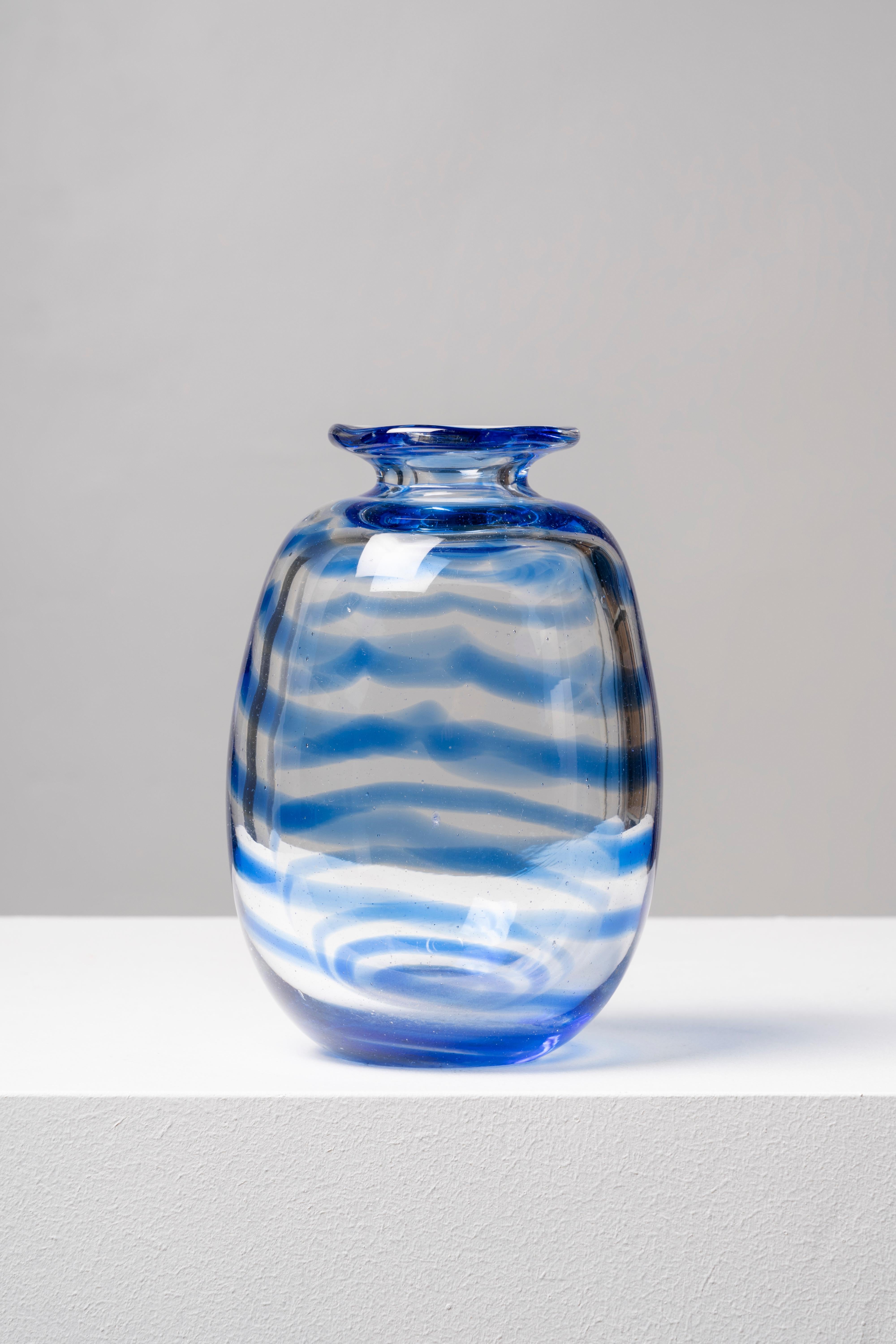 Translucent glass vase decorated with a zigzagging line running around the perimeter.
This is the iconic ornament found in the Blue Bella Carafe collection, which also consists of glasses and jugs. Founded in 1983, the William Yeoward brand enjoys