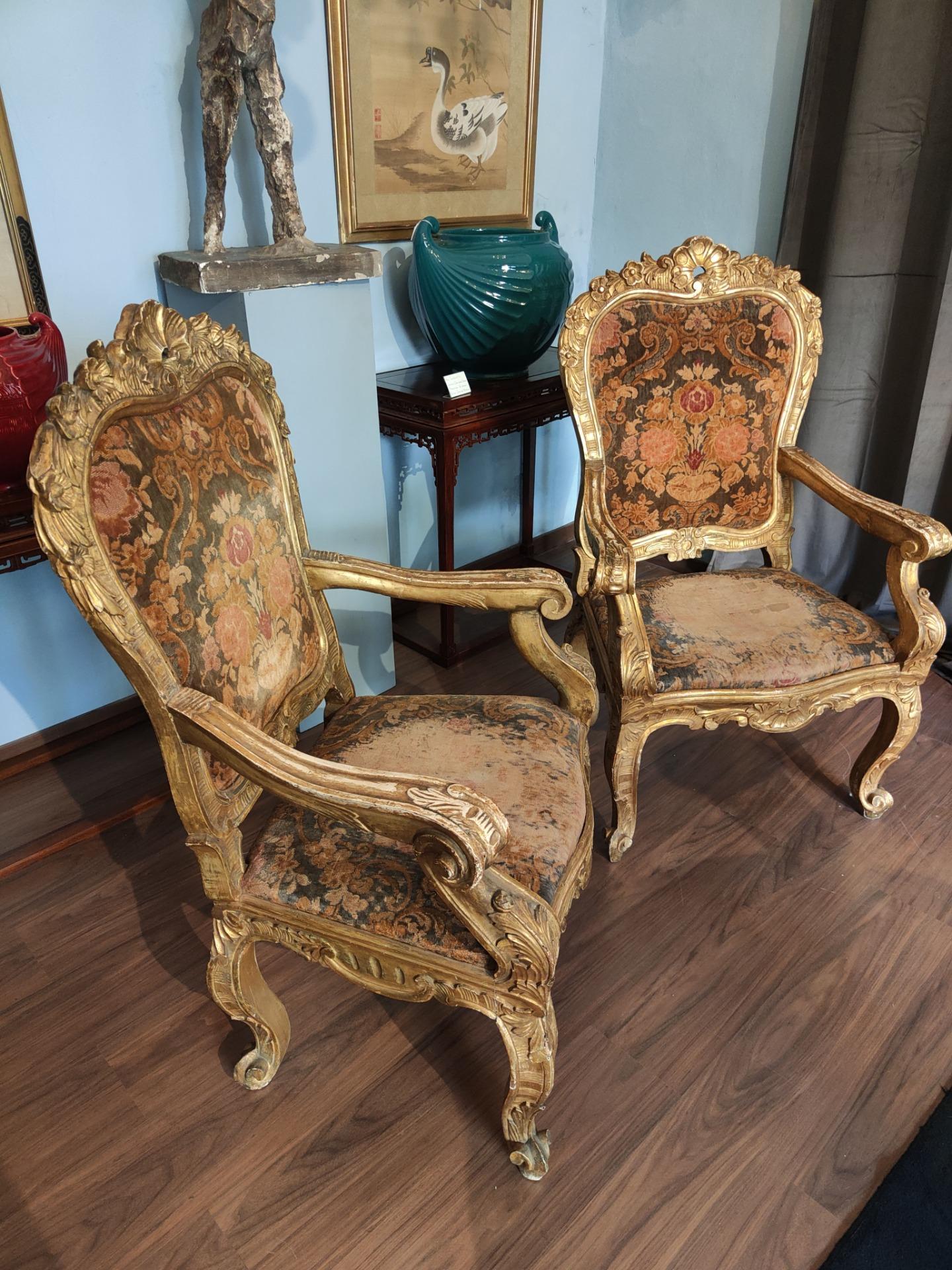Beautiful Pair Of Armchairs, Rome, Period: 600.

Pair of giltwood armchairs, Roman manufacture, finely carved with rich floral and shell motifs. 
The upholstery is velvet; The tones are warm, ranging from browns to oranges to golds.
These armchairs