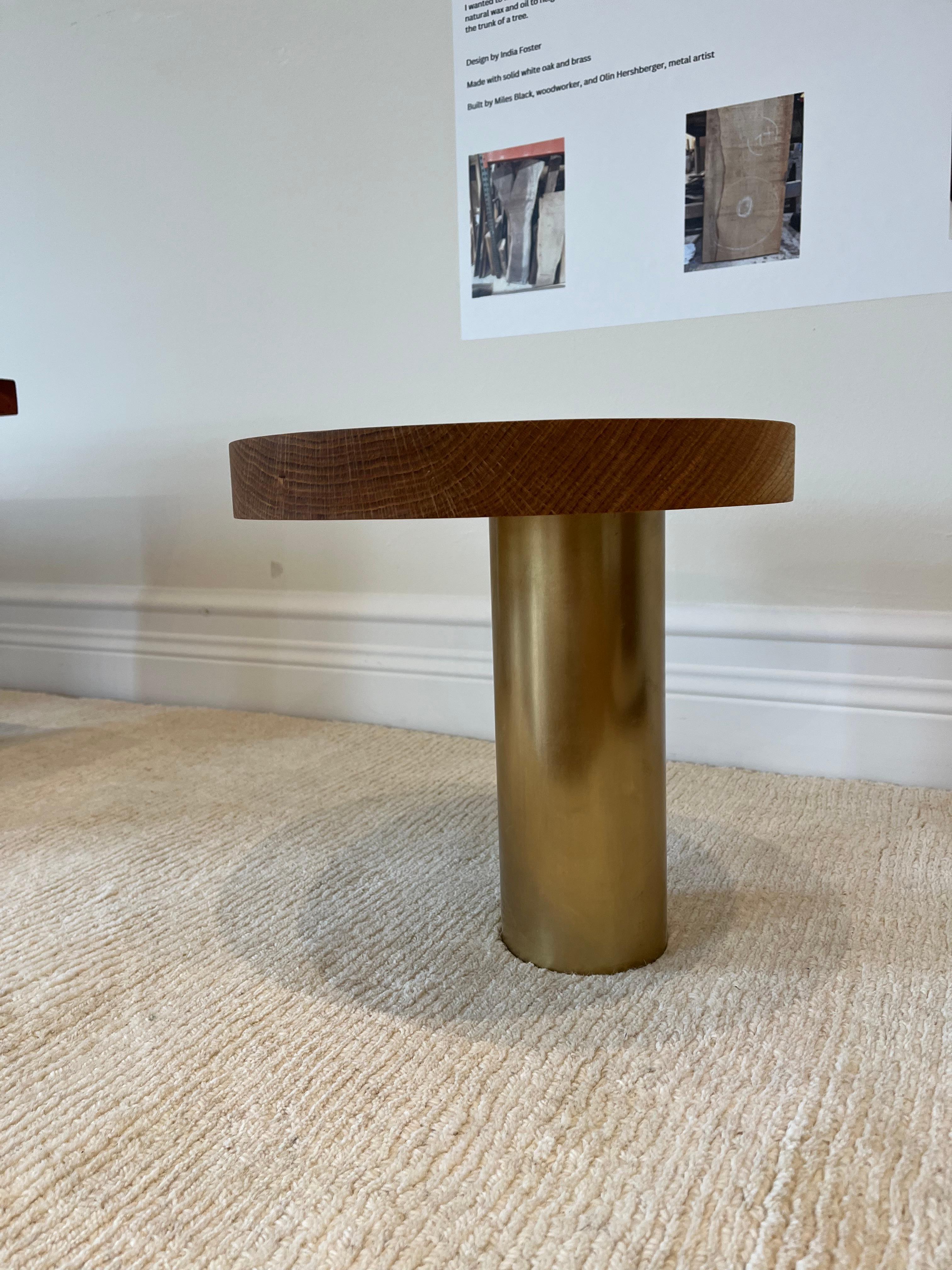 Cette table est fabriquée en chêne recyclé et en laiton massif.  Le plateau est fabriqué à partir d'une pièce de bois massif avec une mortaise légèrement décentrée, laissant apparaître le tenon du pied en laiton massif. Cette table est livrée en