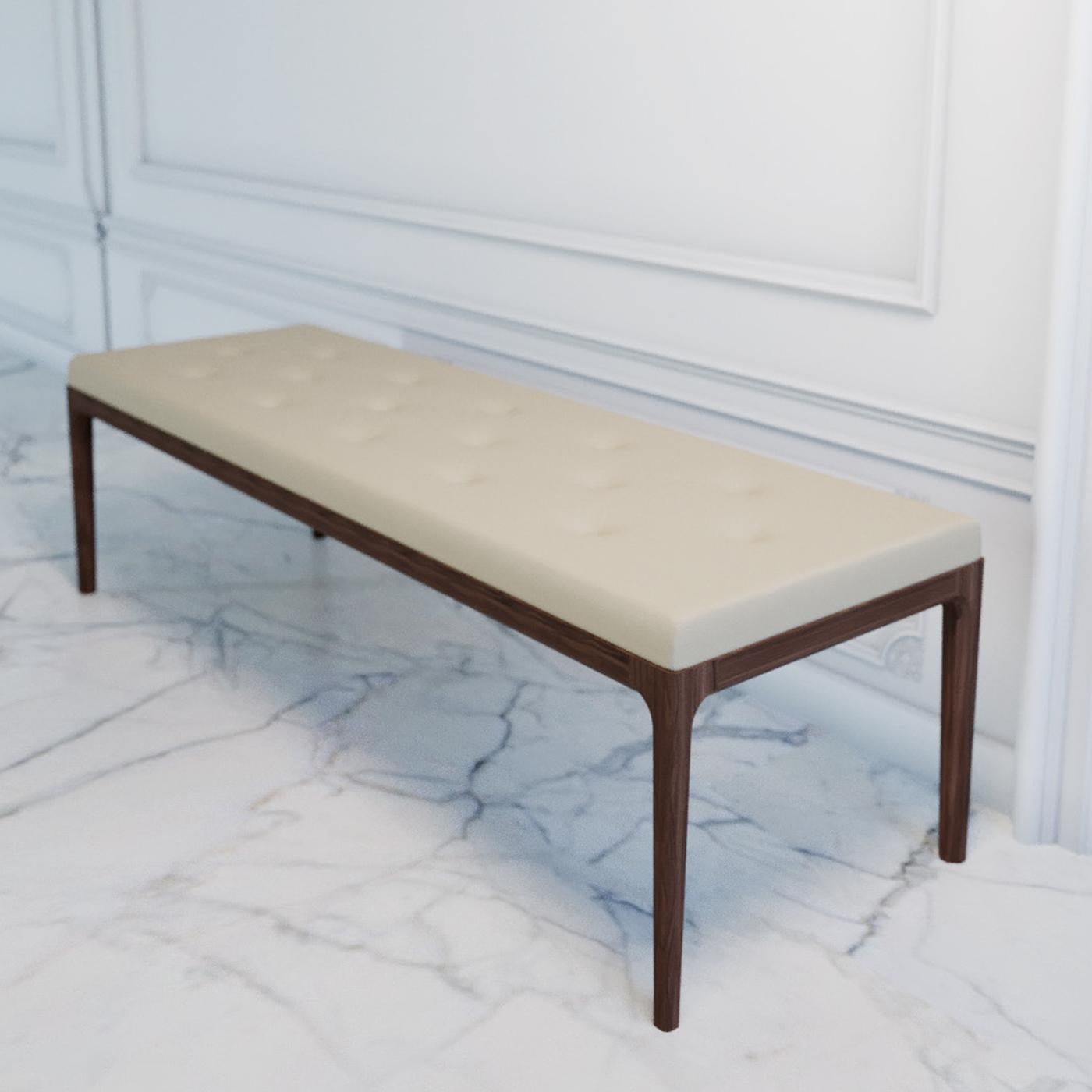 This sophisticated bench showcases an essential silhouette sitting atop four straight legs in solid, walnut-finished ash. The rectangular seat features generous padding, while the quilted beige upholstery lends it a stylish flair. Due to its