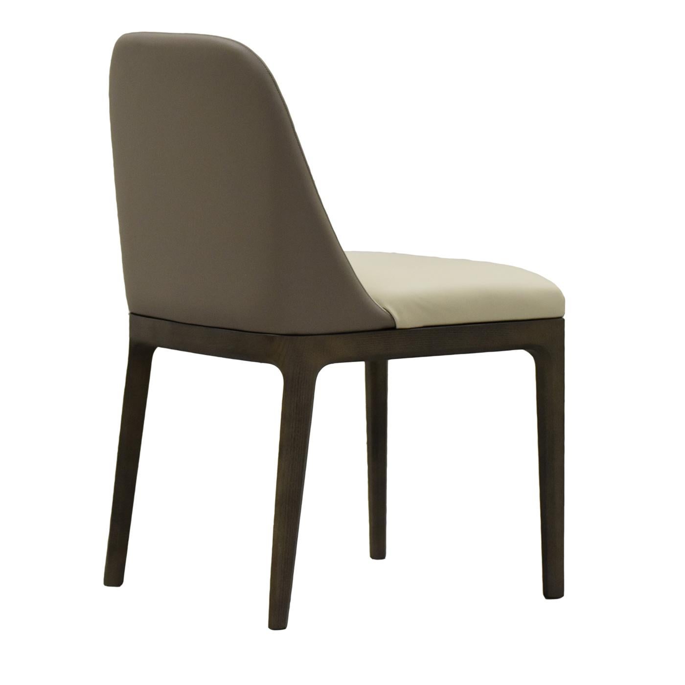 Boasting an essential and cozy silhouette, this elegant chair will be a statement-making piece in black-and-white decors. The padding of rounded seat and backrest renders this piece comfortable, while its white upholstery sets a stunning contrast
