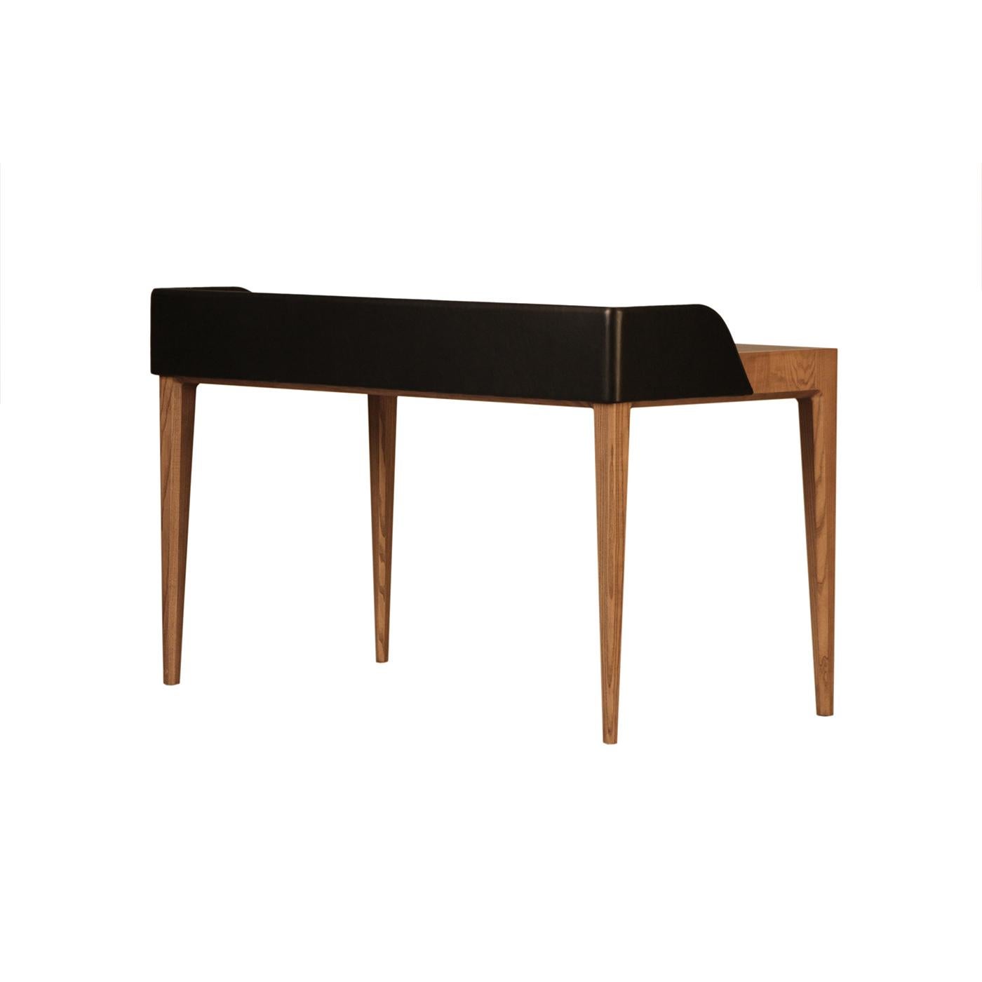 Brimming with luxe flair, this exceptional desk will be a mesmerizing addition to contemporary decors. The durmast-finished ash wood frame comprises four tapered, slender legs sustaining a parallepiped-like table top upholstered with prized leather.