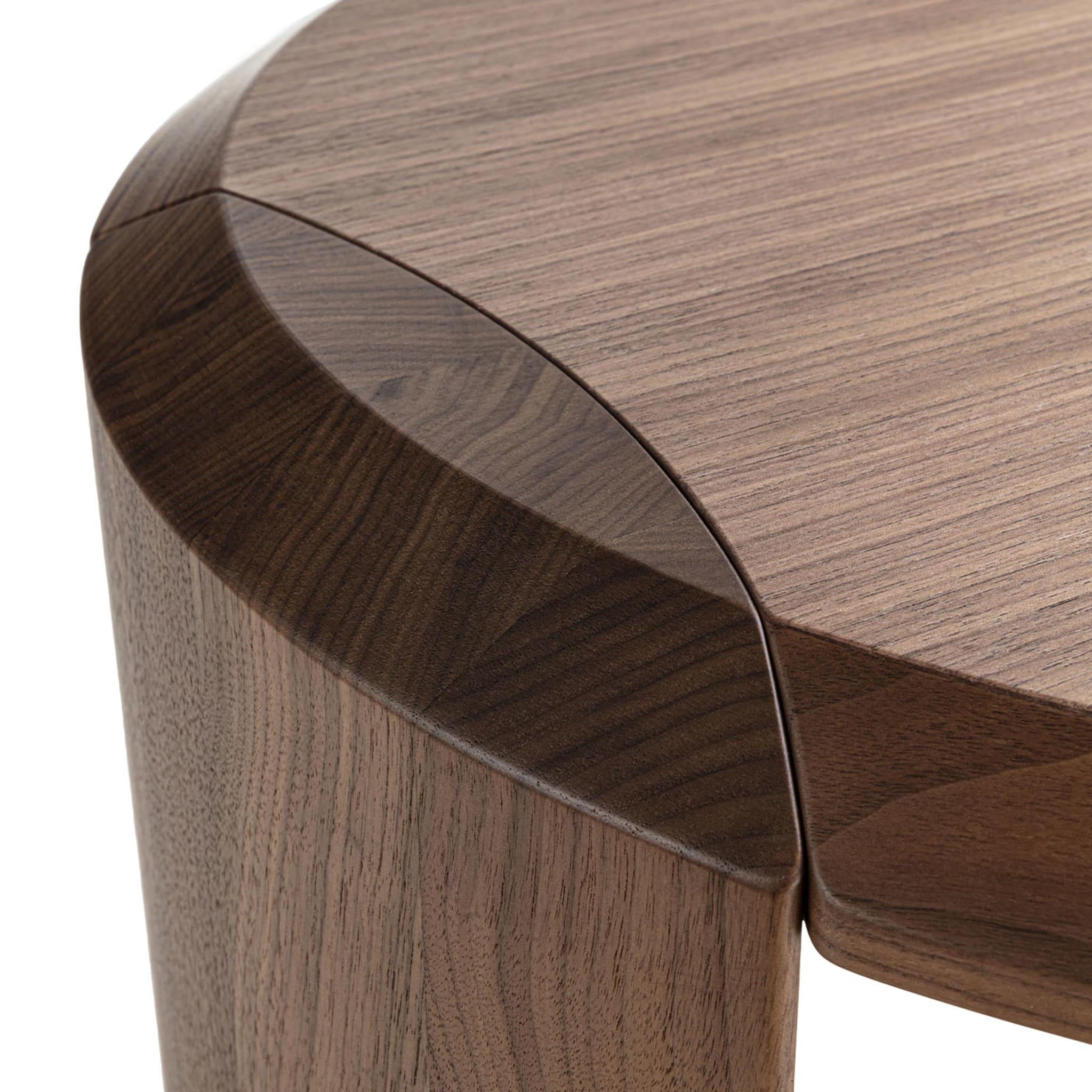 Elegantly-distributed geometric volumes define this sleek round side table, refined addition to interiors of modern and contemporary inspiration, alike. Characterized by a special seamless joint between the top and the almond-cut legs, the design
