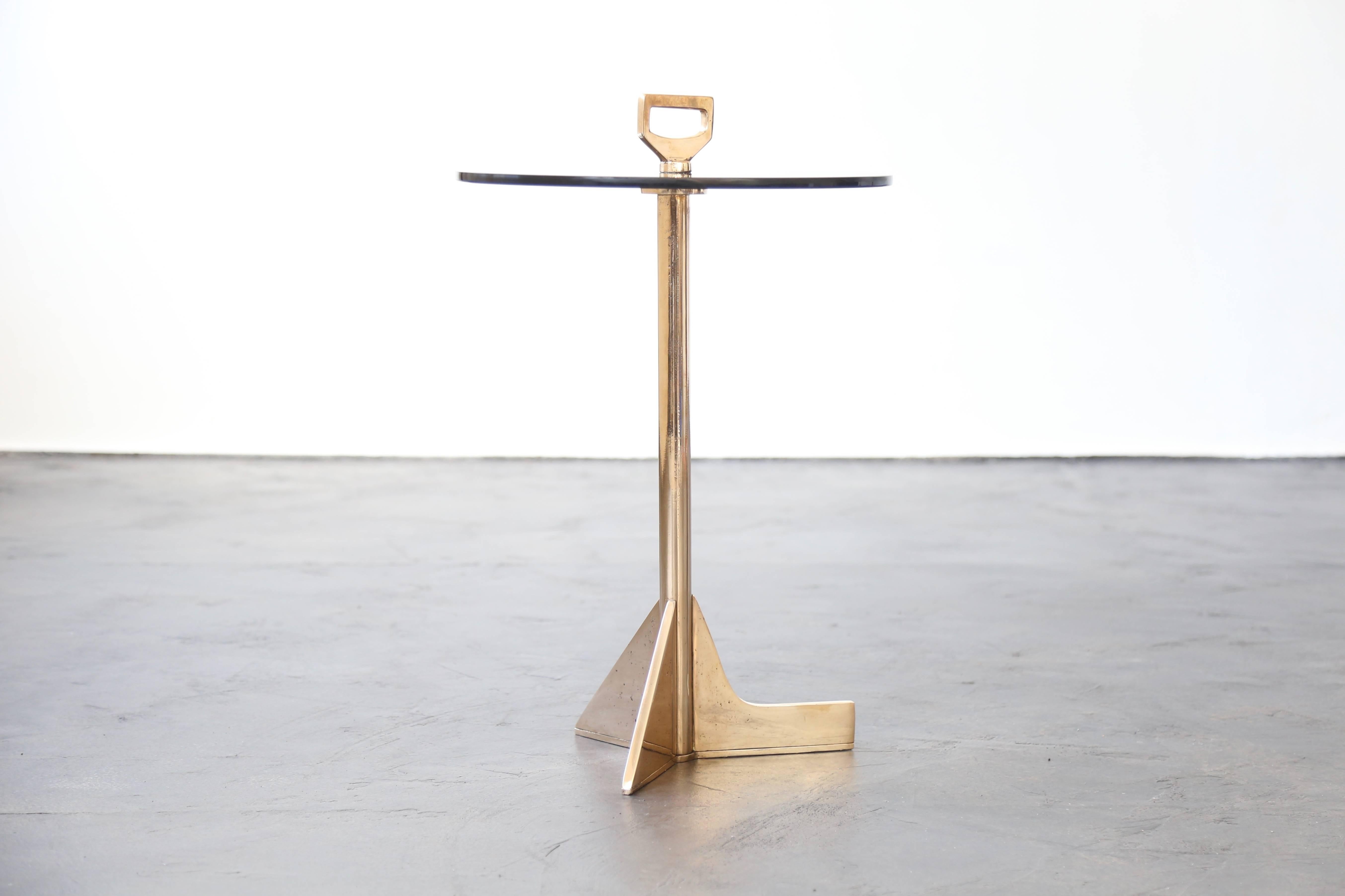 This playful table made of cast bronze and smoked glass features asymmetrical 