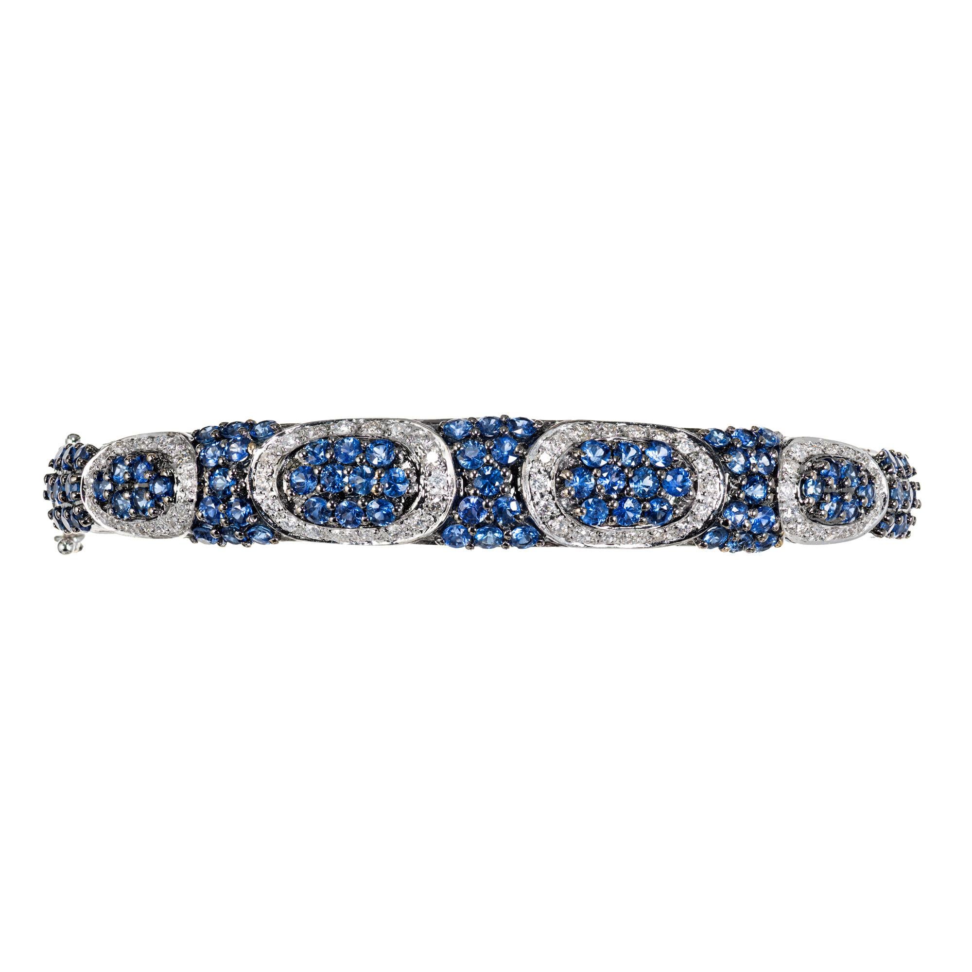 Sapphire and diamond bangle bracelet. 83 round sapphires totaling 4.15cts, set in a 18k white gold bangle setting. The clustered sapphires are separated buy buy 72 full cut round diamonds approximately .50cts, in white gold ovals. The bangle fits a