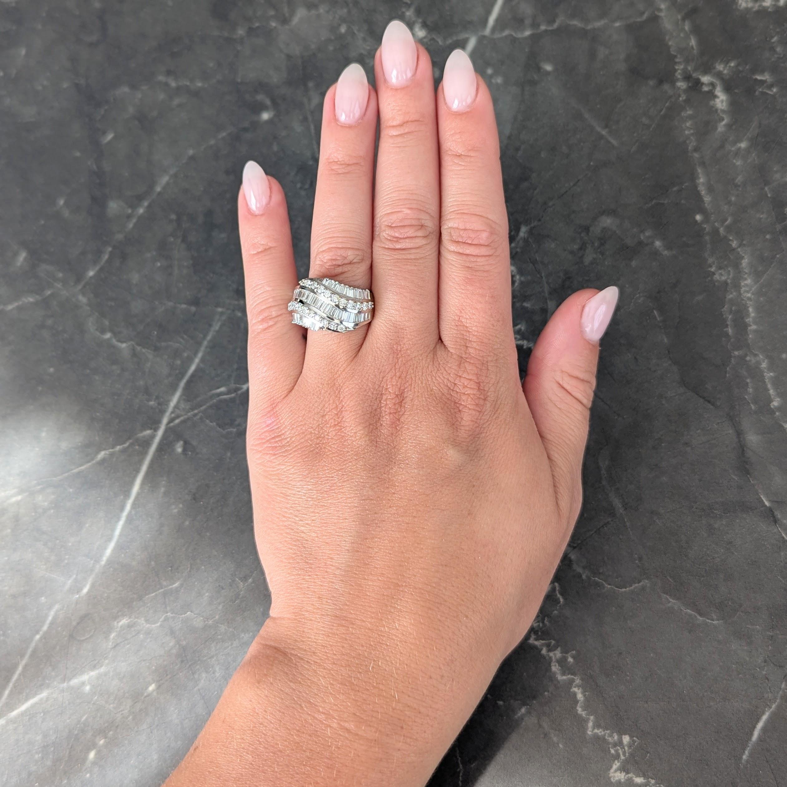 Designed as a slightly domed band channel set with twisting rows of diamonds
Comprised throughout with baguette cut and round brilliant cut
Weighing approximately 2.25 carats total
Collectively G/H color with VS2 clarity
With high polish