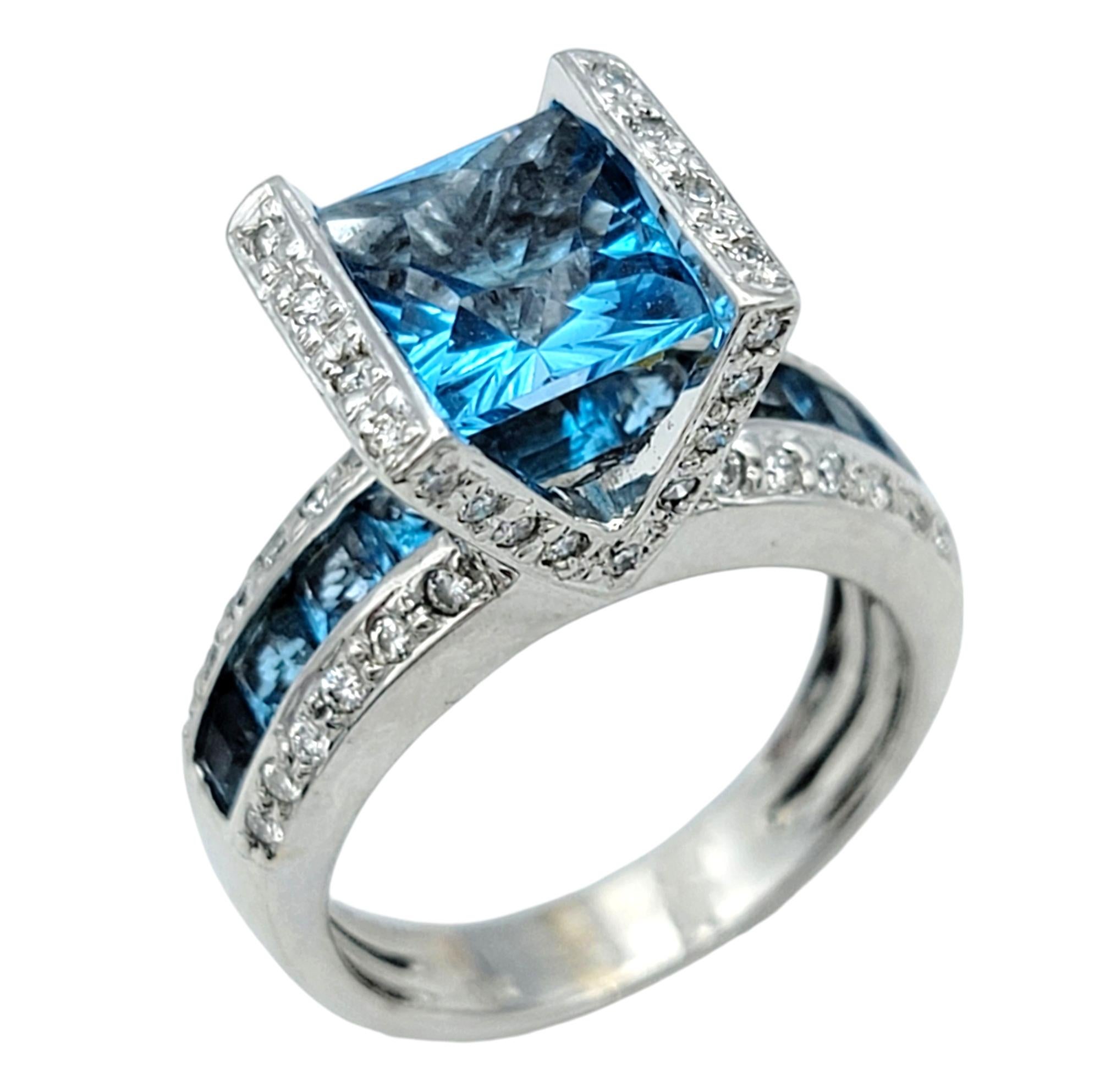 Ring Size: 7 

Indulge in modern luxury with this exquisite Bellarri cocktail ring, a true statement piece that radiates elegance and brilliance. At its center, a stunning princess cut topaz draws you in with its captivating hue. This vibrant topaz