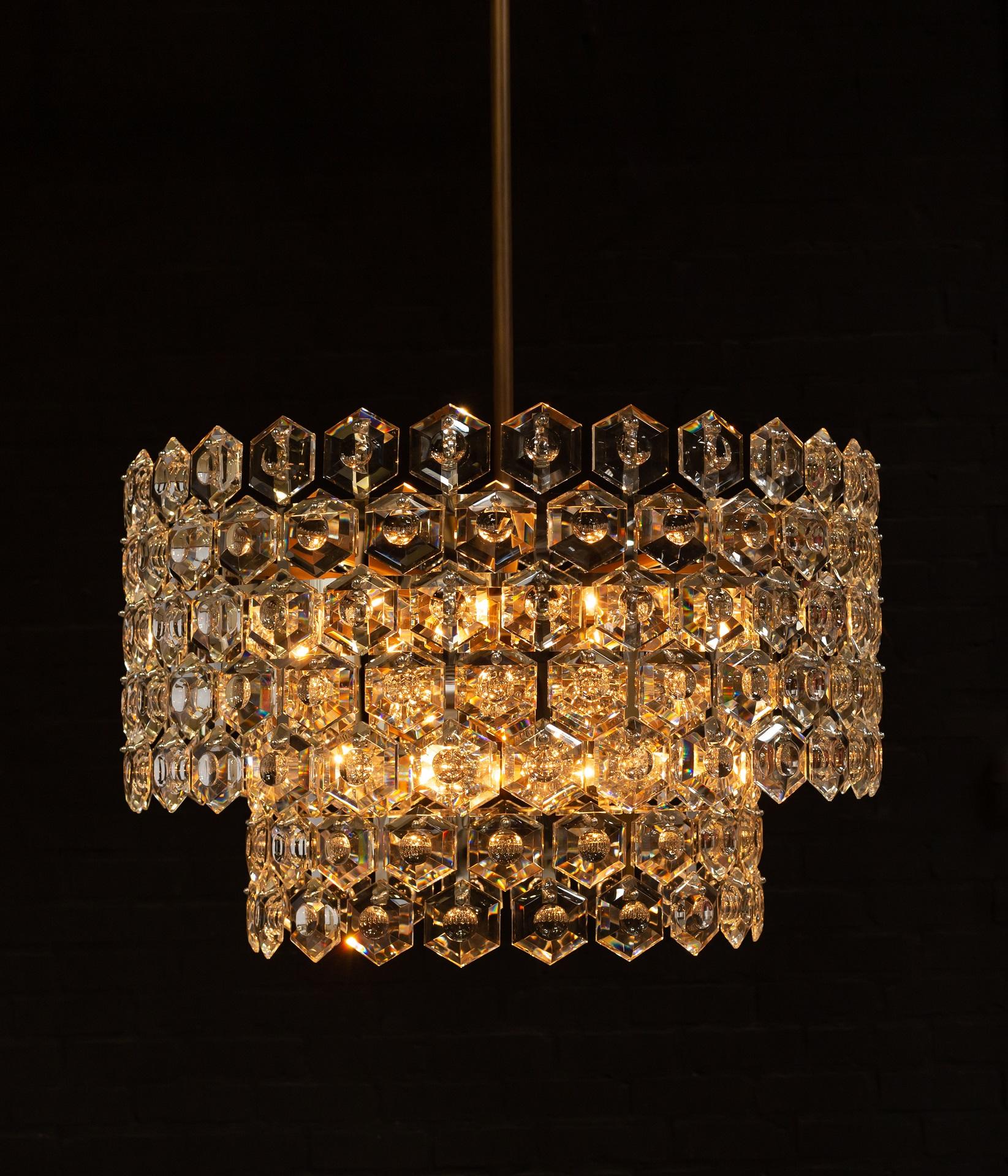 Halos of luxurious crystal hexagons - faceted with a custom carved concave detail - defuse and refract light within and throughout. Elusive and illusory, BELLAZA casts a symphony of light and shadow.

Offered in single and layered double tiers with