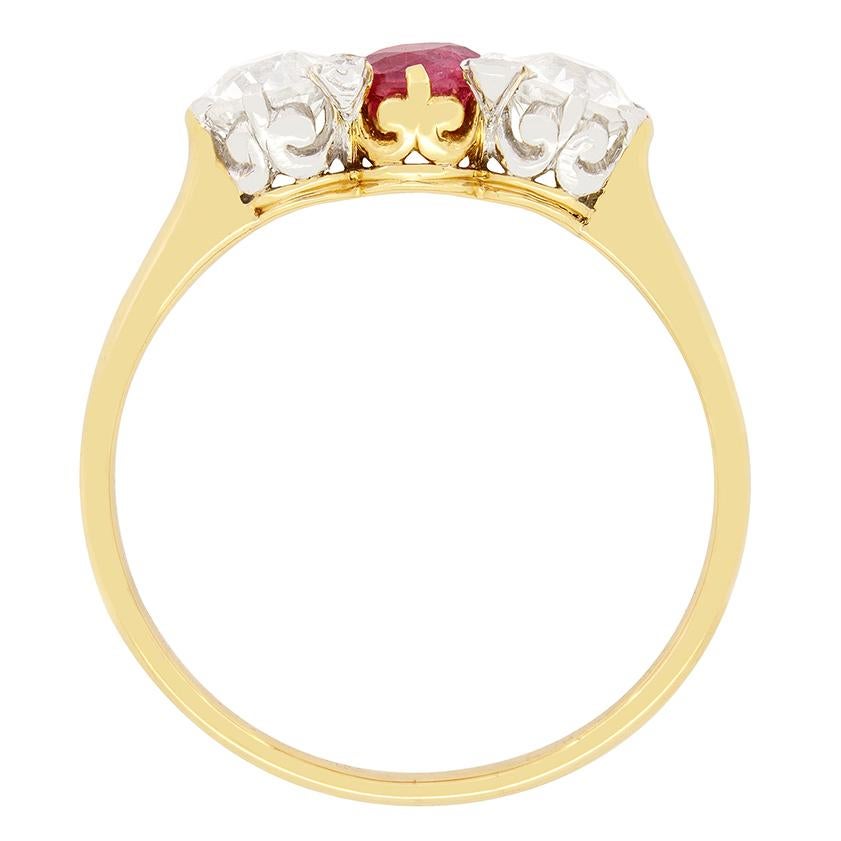 Ein üppiger Rubin wird bei diesem französischen Trilogie-Ring von zwei glitzernden Diamanten im Altschliff flankiert. Der Rubin ist ein altgeschliffener Stein mit einem Gewicht von 0,40 Karat und ist in 18 Karat Gelbgold gefasst. Die beiden